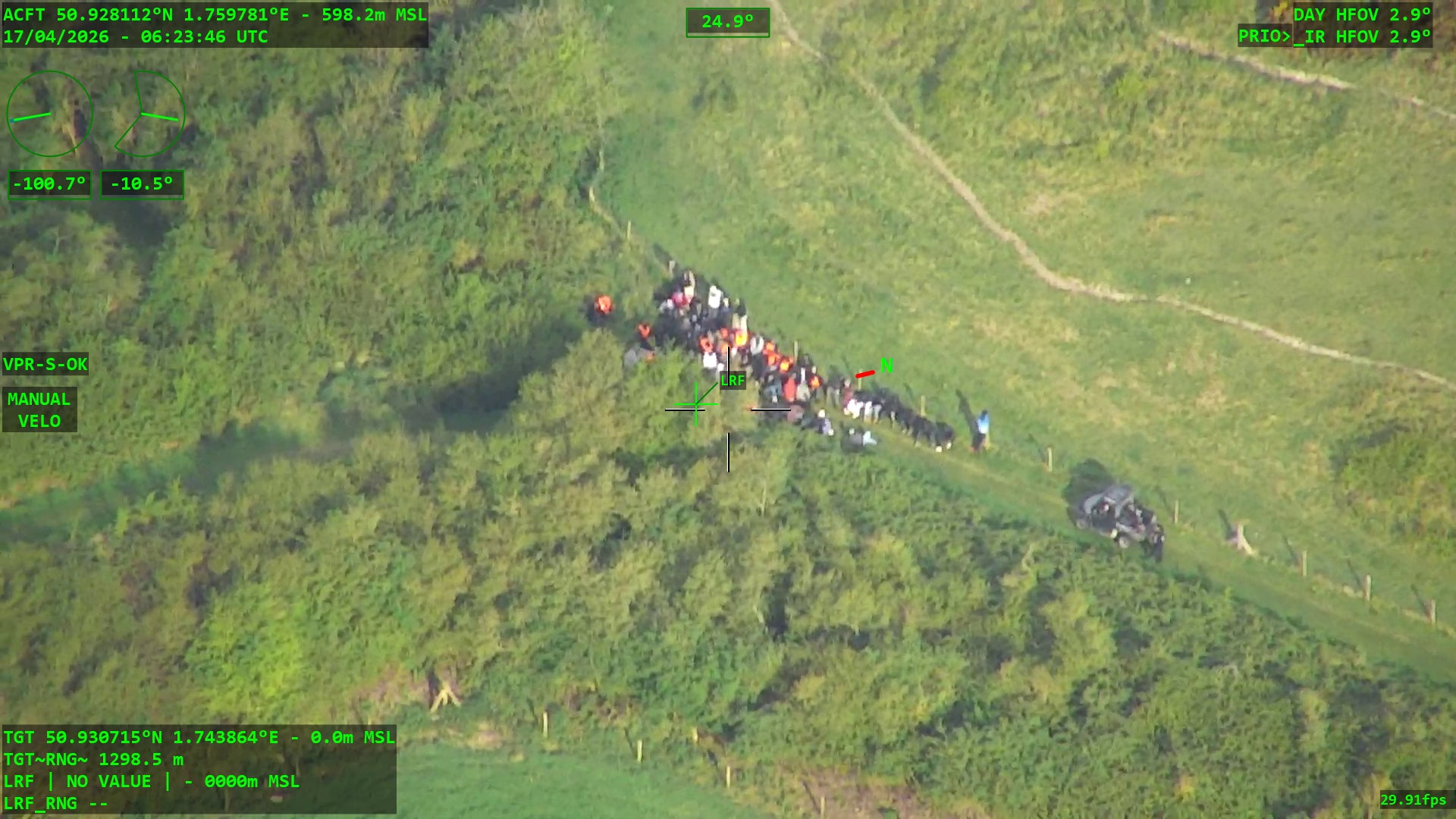 Police surveillance of a large group of migrants attempting a small boat launch