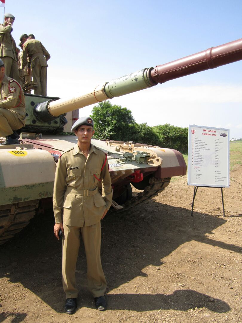 Shubham Gupta in front of a tank during his training at NDA