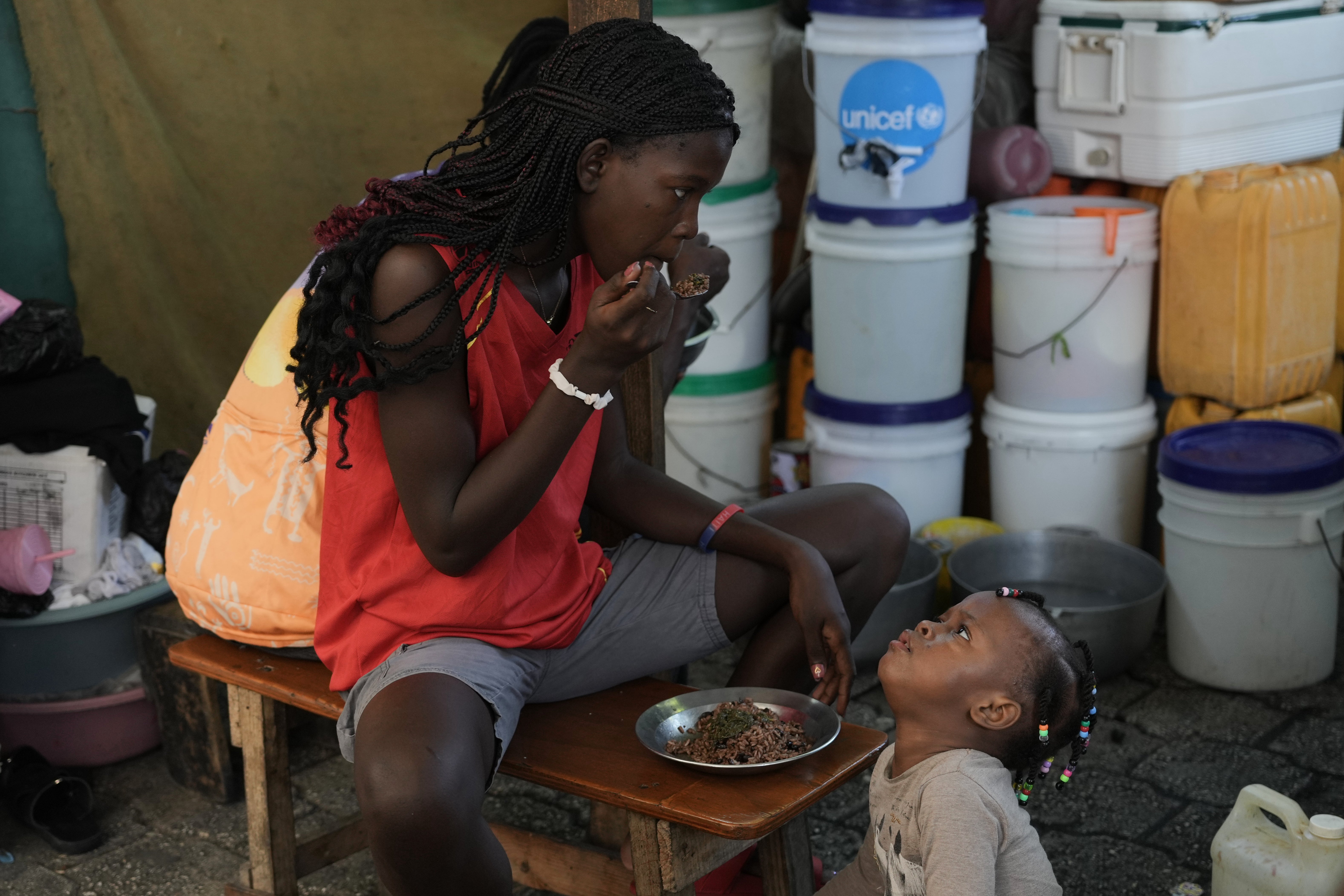Children eat at a shelter for families displaced by gang violence in Port-au-Prince, Haiti, Wednesday, Aug. 19