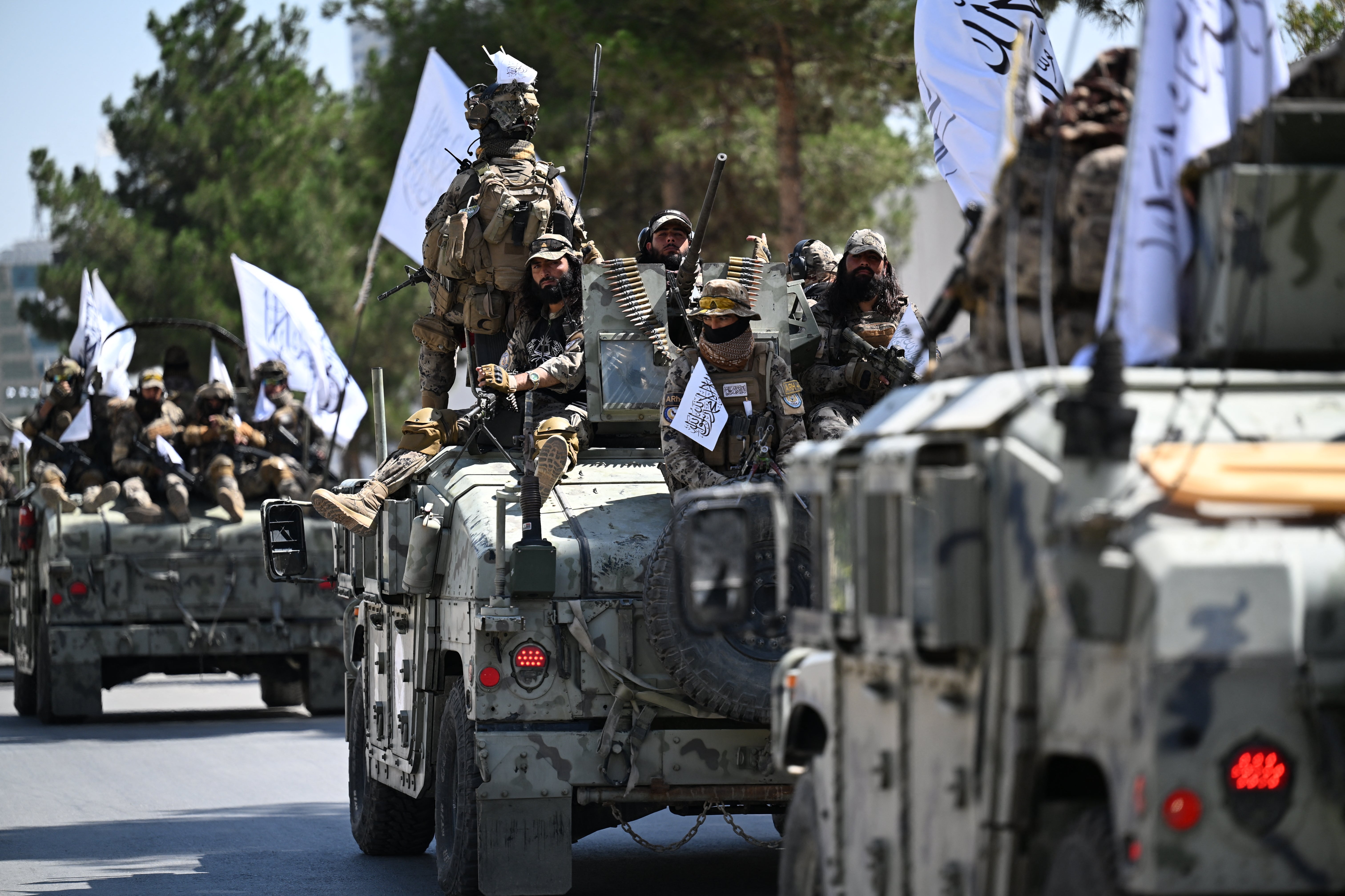 A convoy of Taliban security personnel take part in a parade in front of the former US Embassy building in Kabul