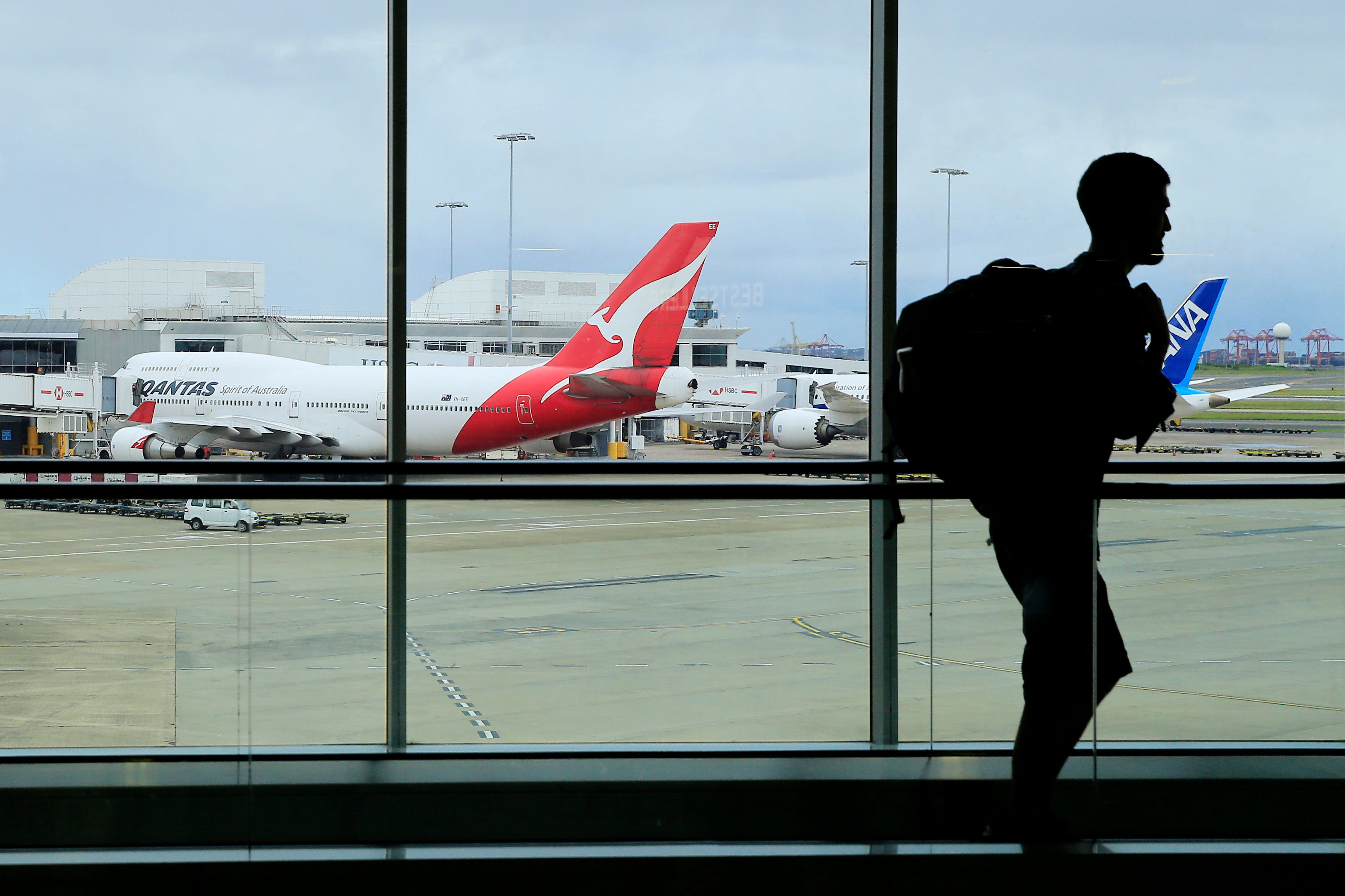: A passenger walks past a Qantas jet at the International terminal at Sydney Airport on March 10, 2020 in Sydney, Australia