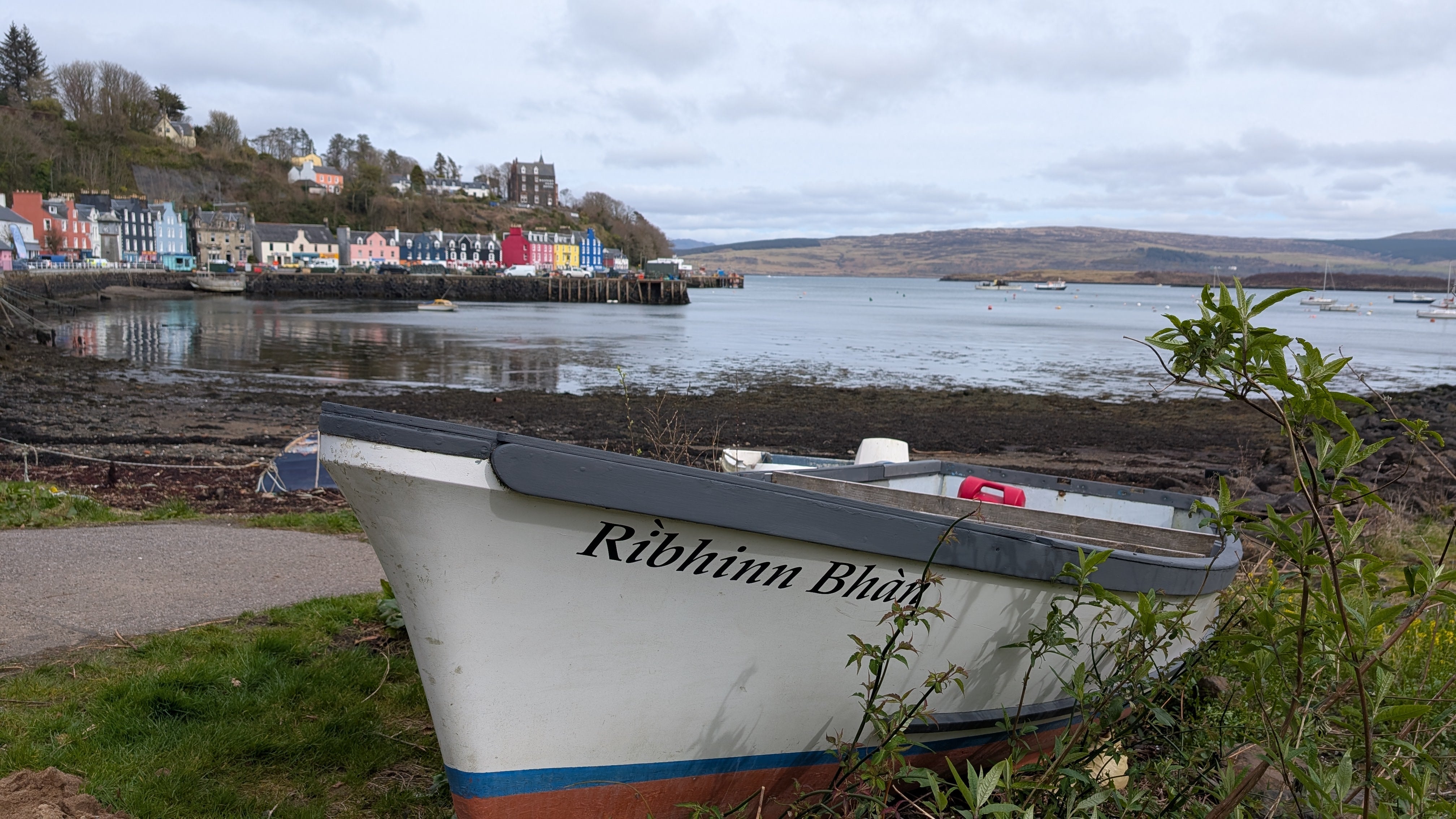 A fishing boat with the colourful houses of Tobermory in the background
