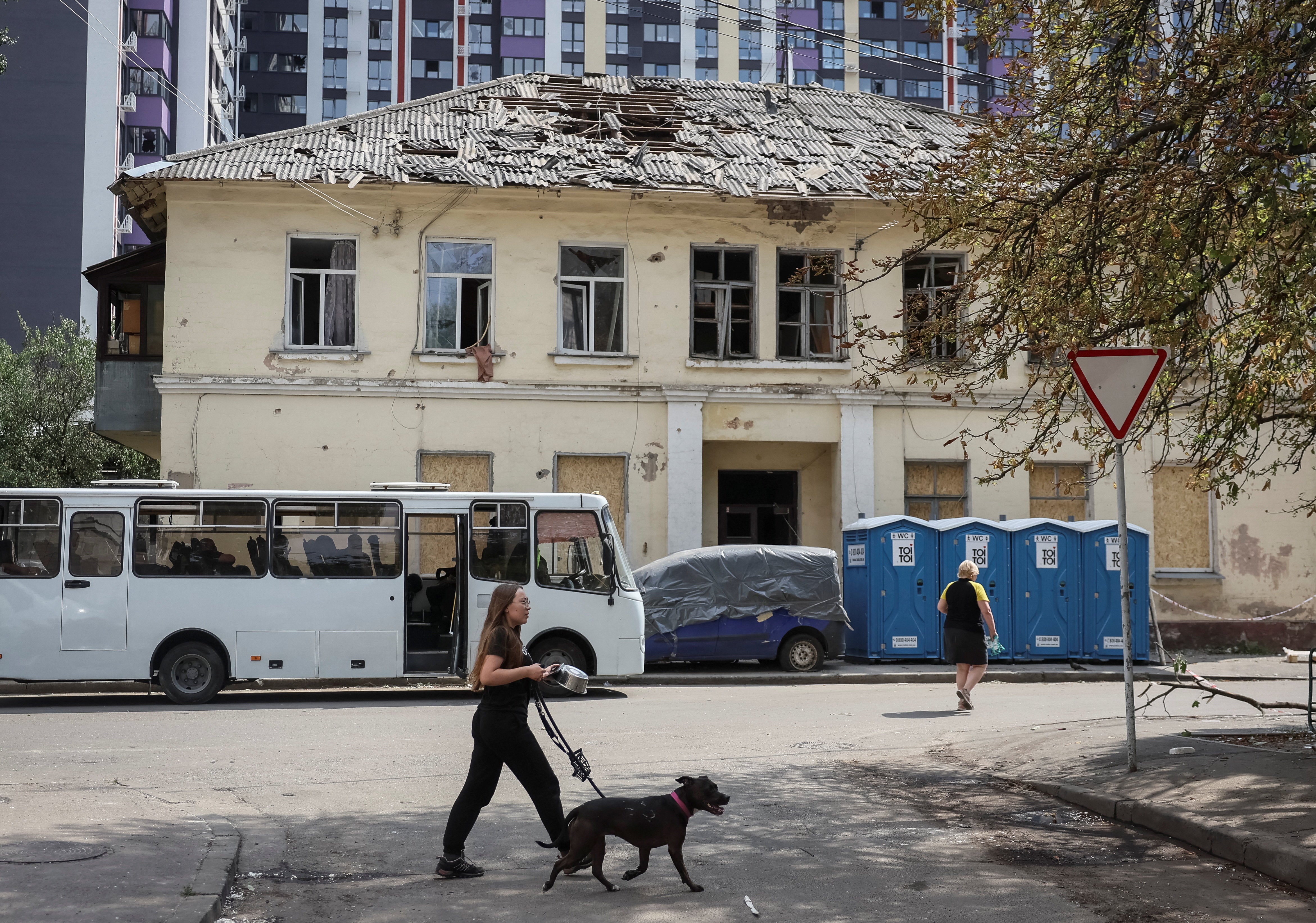 A woman with a dog walks past the aftermath of Russia's attack on Ukraine, in Kyiv, Ukraine August 21, 2026. REUTERS/Gleb Garanich (Reuters)