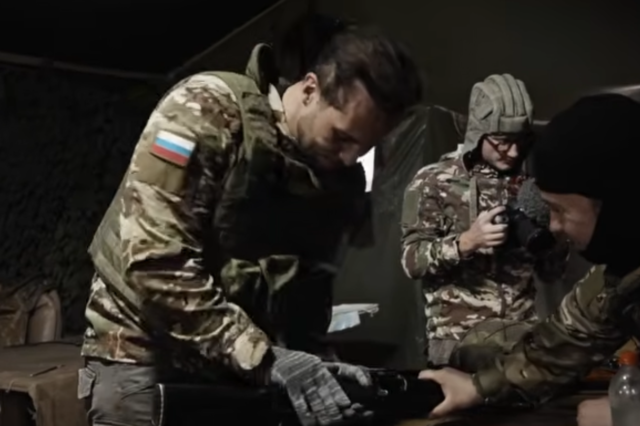 Tristan Tate in camouflage adorned with the Russian flag (Tate Confidential)