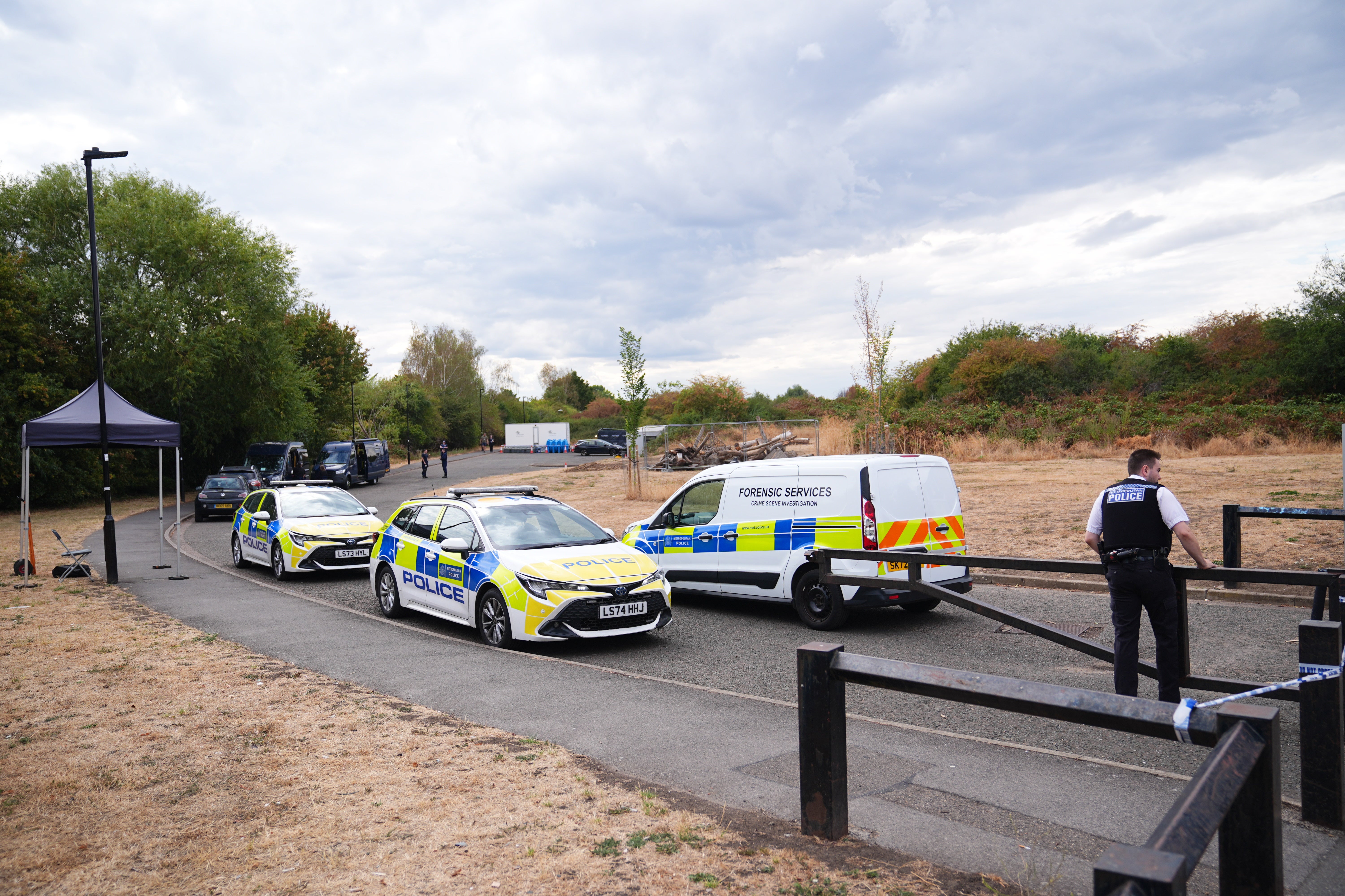 Police activity near to the scene, where a member of the public found human remains in woodland in Feltham, south-west London