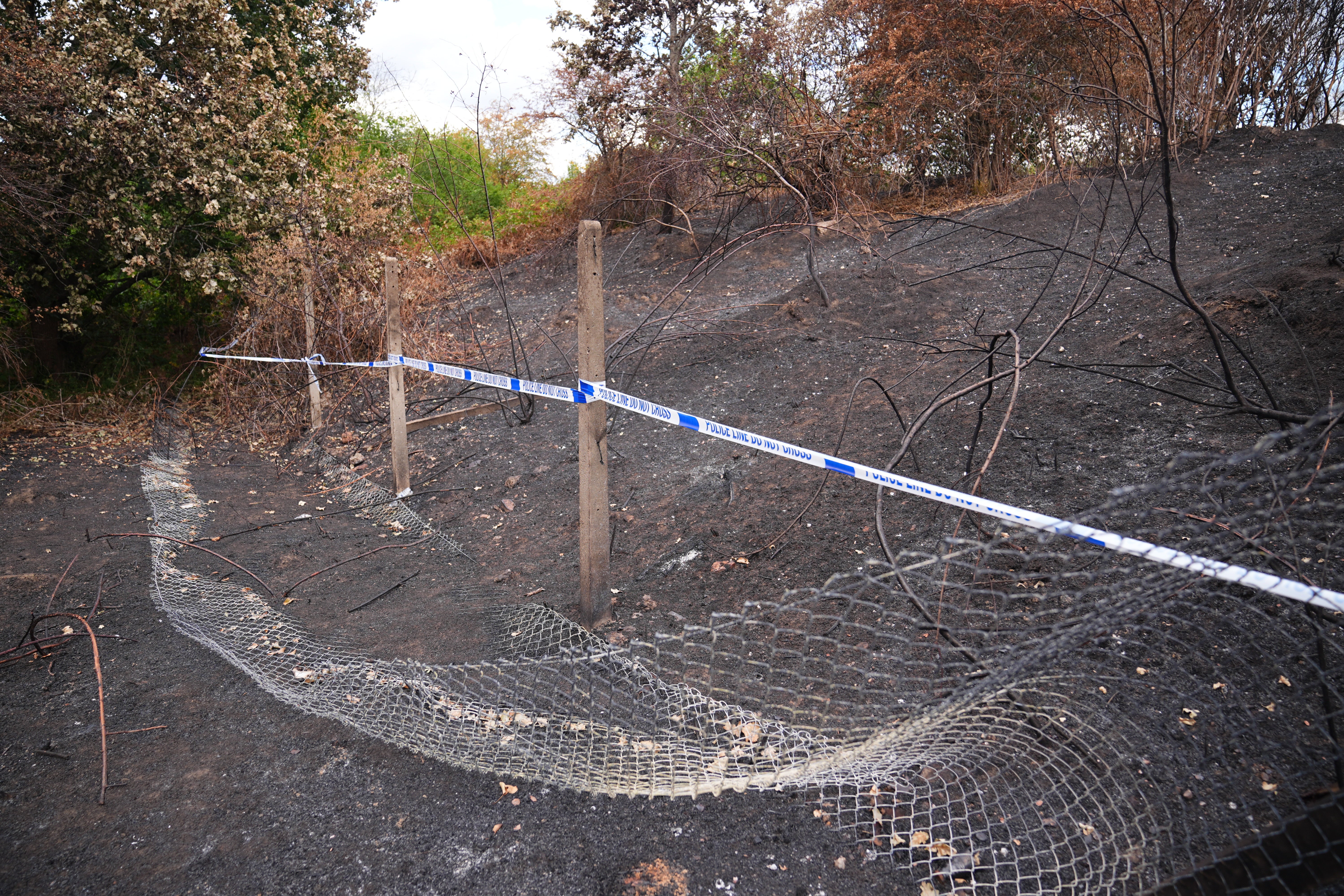 Police tape near to the scene, where a member of the public found human remains in woodland in Feltham, south-west London