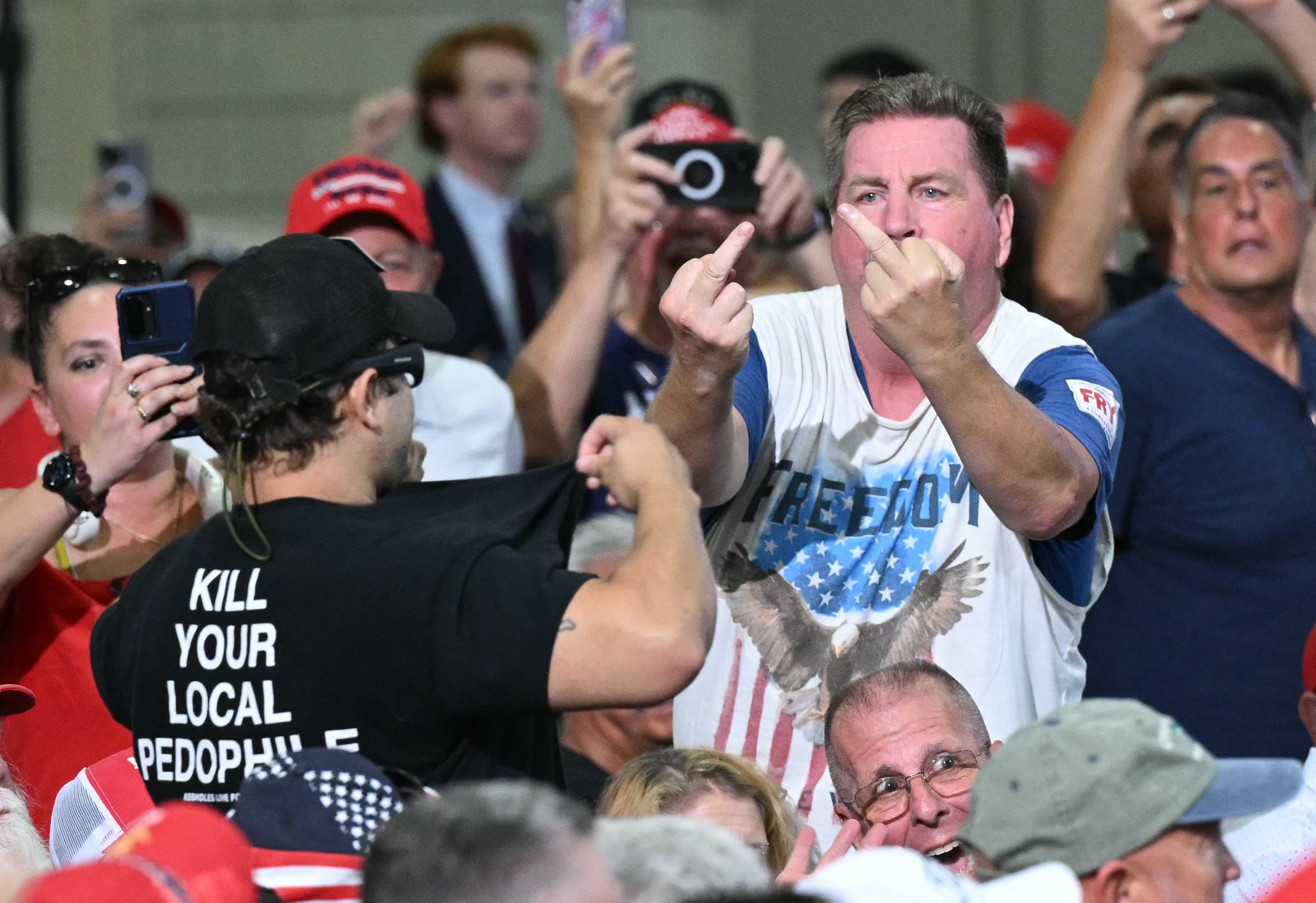 Supporters of US President Donald Trump make rude gestures toward a protester wearing a shirt reading "Kill Your Local Pedophile" as Trump attends a rally in support of US Senator Darline Graham at the Myrtle Beach Convention Center in Myrtle Beach, South Carolina, on August 21, 2026. (Photo by SAUL LOEB / AFP via Getty Images)