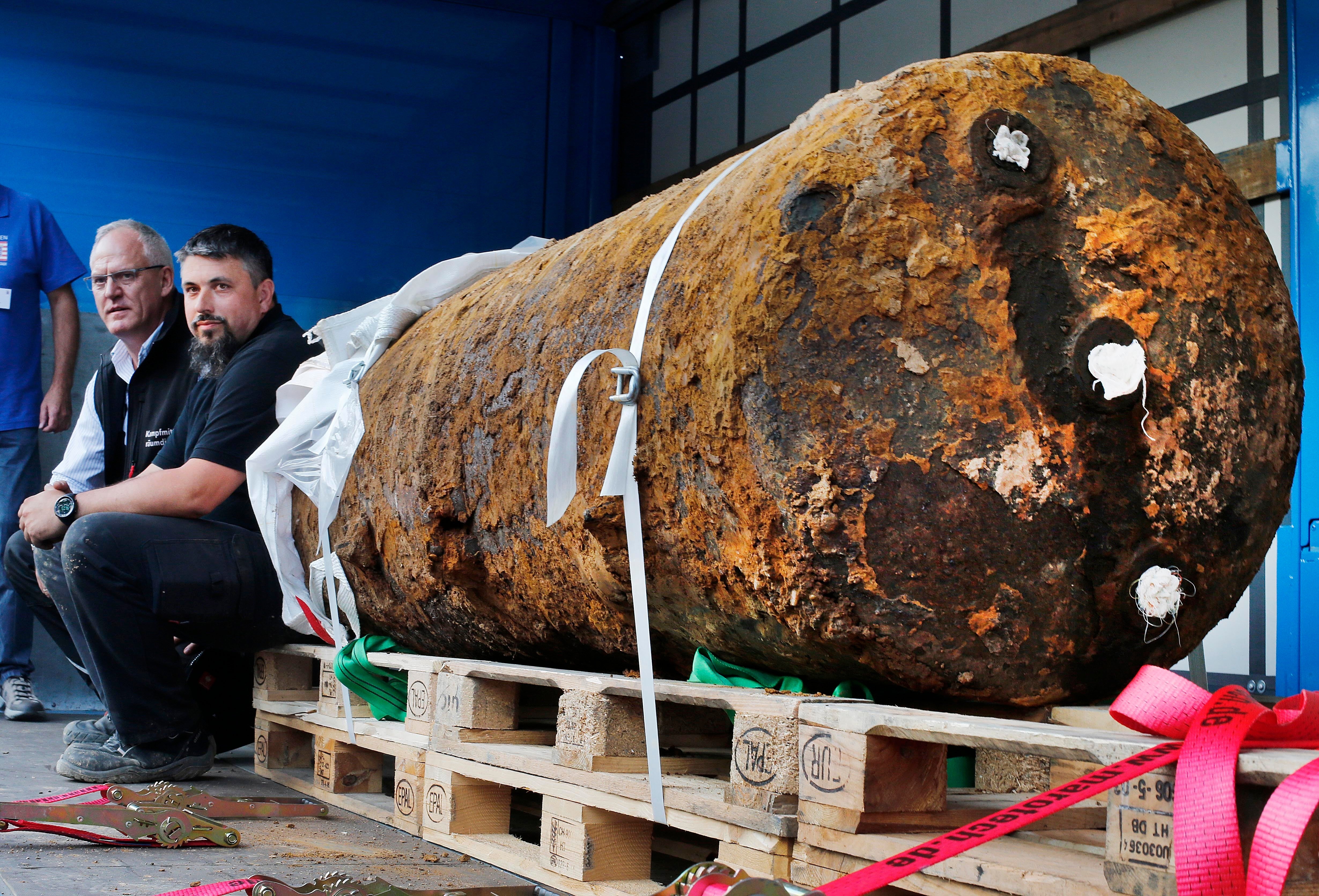 Members of a bomb disposal unit, Dieter Schwaetzler, left, and Rene Bennert sit next to an 1.8-tonne Second World War bomb after defusing it in Frankfurt, Germany, in 2017