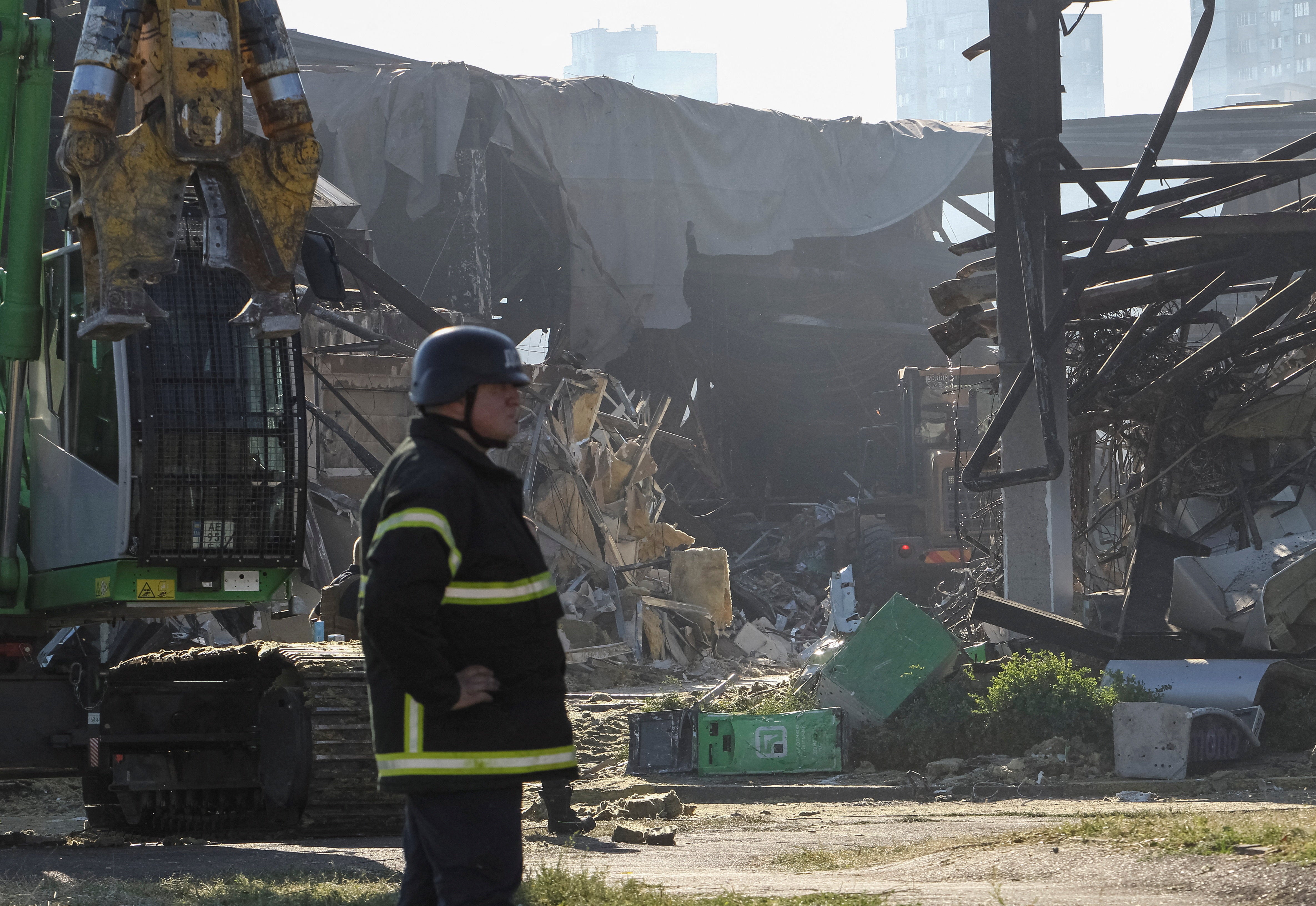 Rescuers work at the site of a shopping centre destroyed by Friday's drone attack by Russia