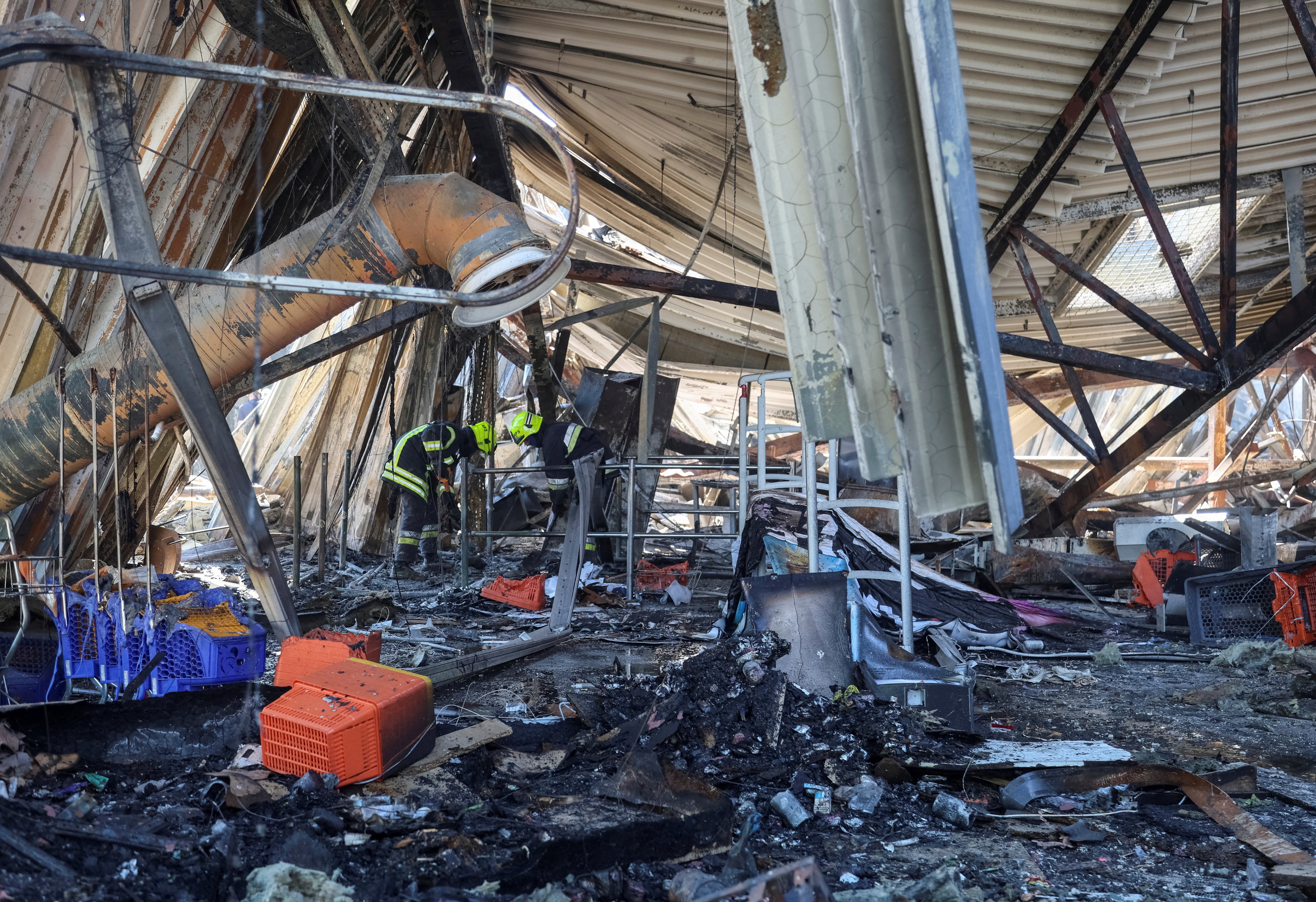 Rescuers work at a site of a shopping centre destroyed by yesterday's Russian drone attack