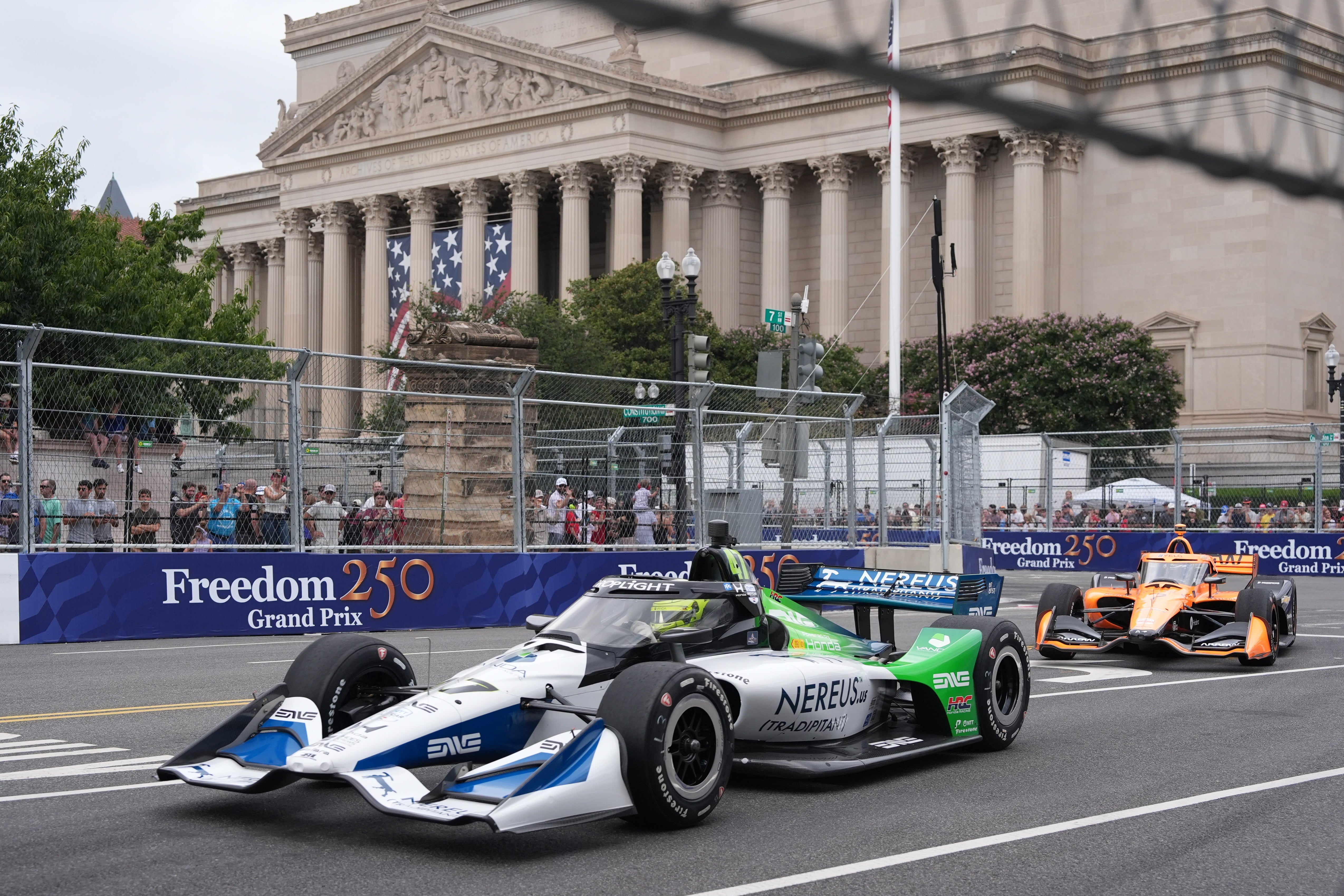 Race car drivers Mick Schumacher, front, and Christian Lundgaard, rear, are seen as they take a turn past the National Archives building in August