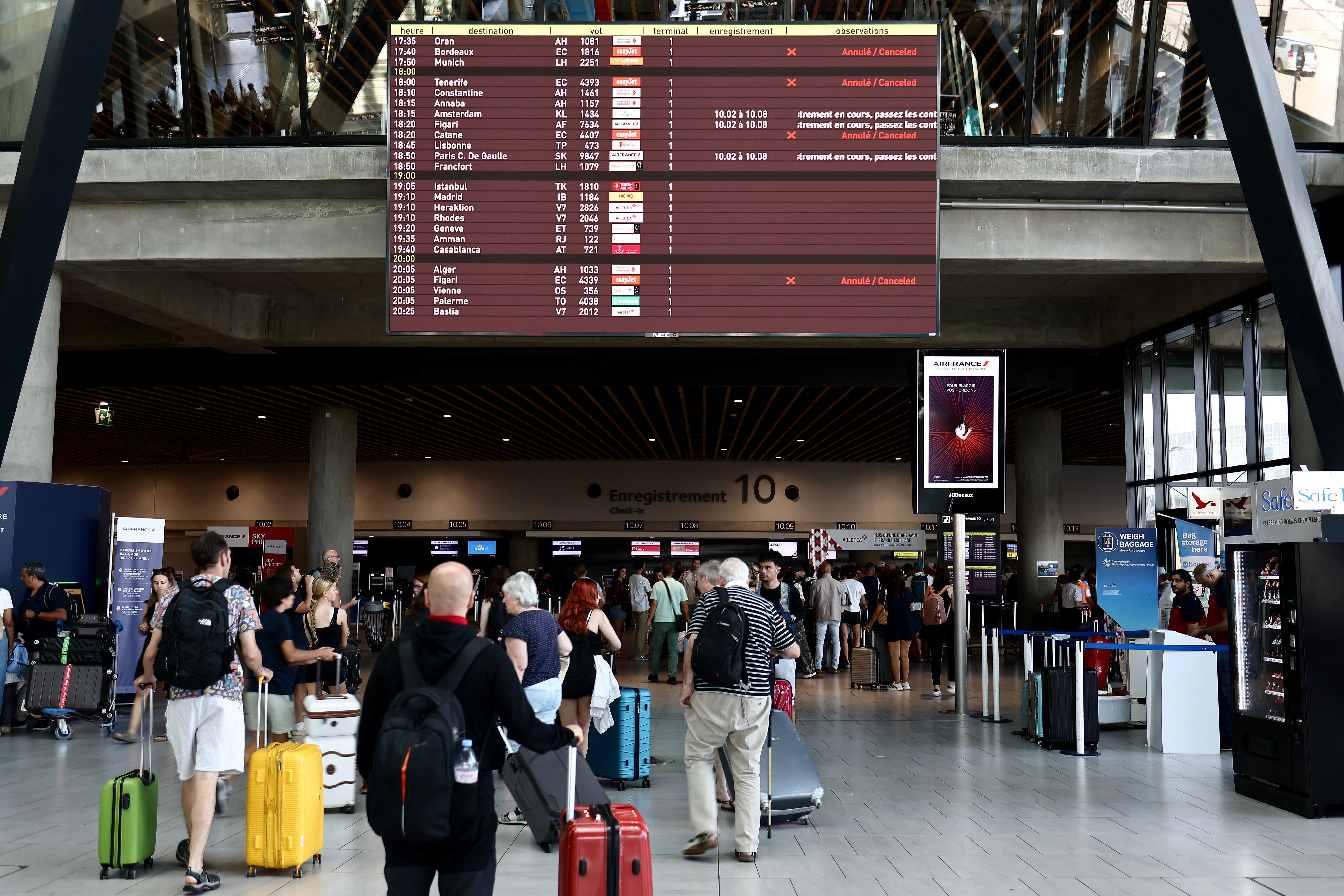 Passengers wait at an airport in Lyon, France, as flights are cancelled due to EasyJet strikes