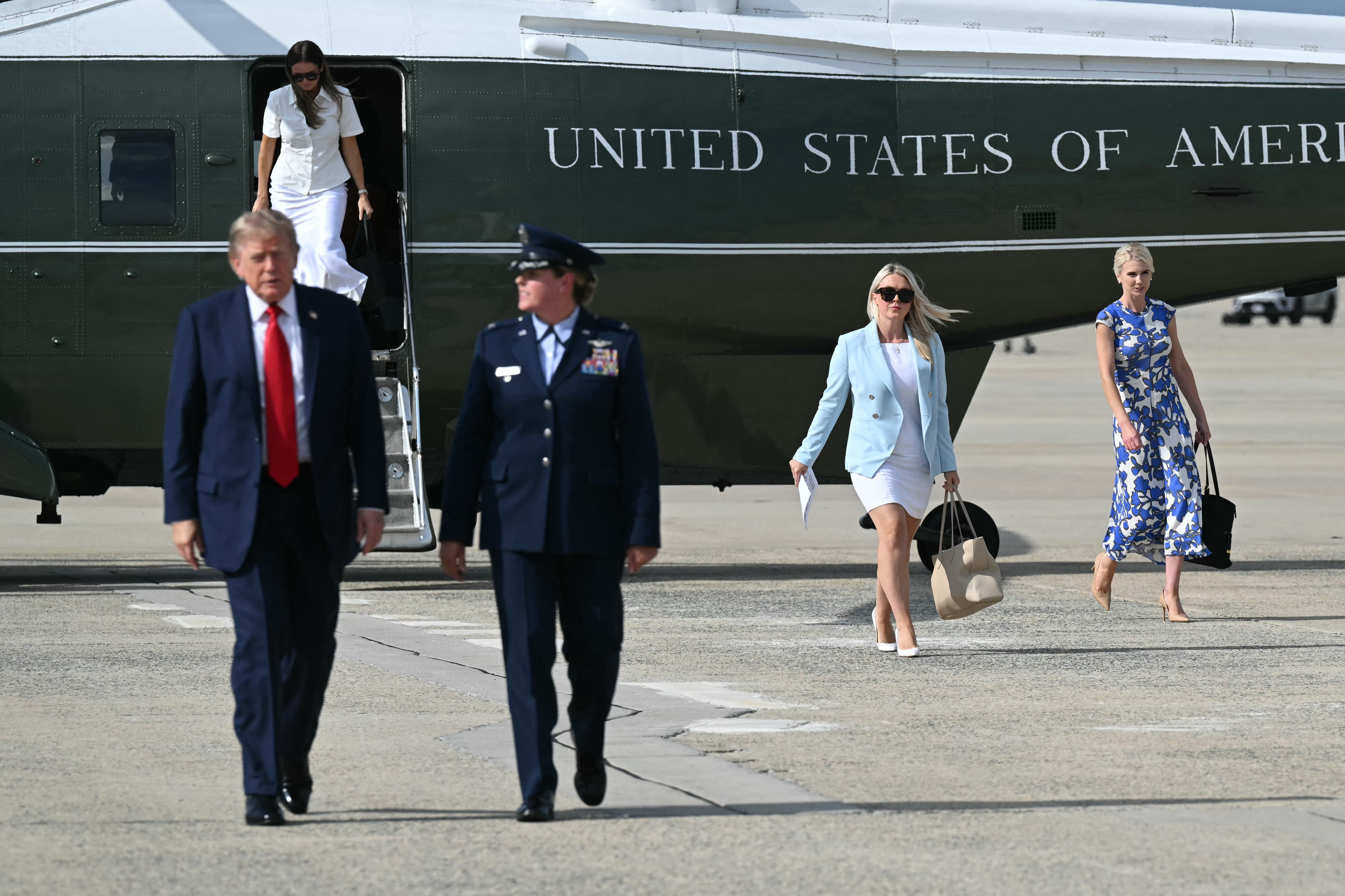 Natalie Harp and White House press secretary Karoline Leavitt trail the president at Joint Base Andrews as he heads to a campaign rally in South Carolina Friday