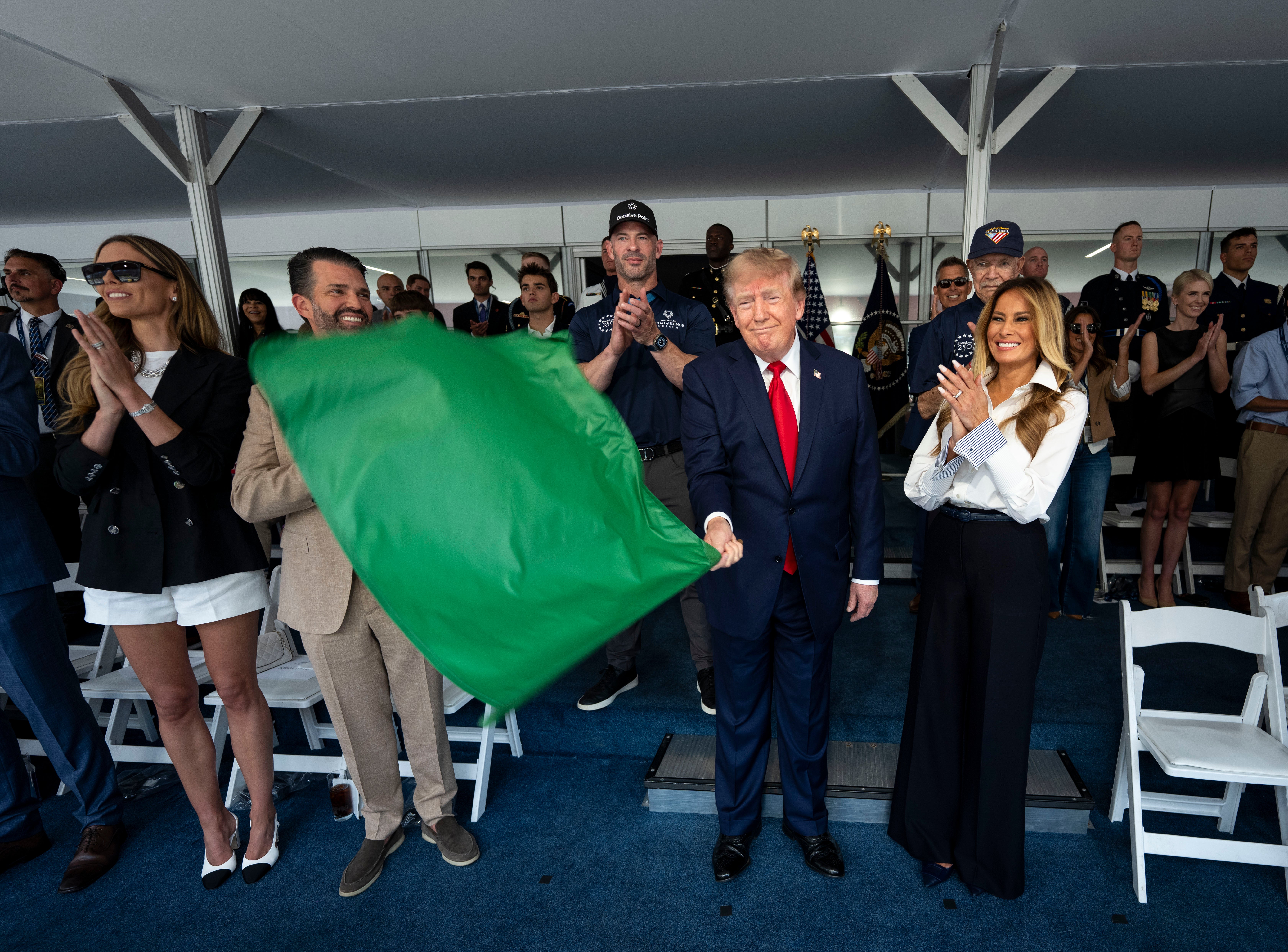 President Trump’s family, members of his administration and close aides, including Natalie Harp (pictured back right), surrounded him in the viewing stands for the Grand Prix