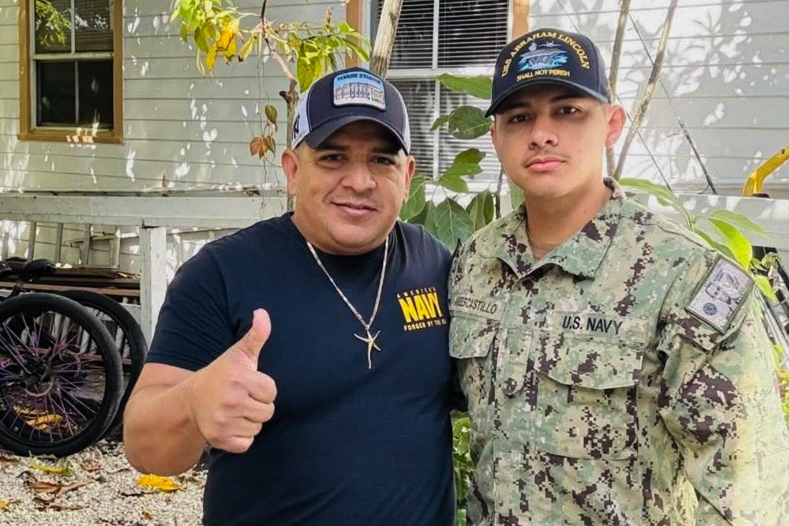 In this photo courtesy of Katherine Delgado shows her step-father Luis Manuel Aviles, left, and her brother Joshua Aviles stand outside their home in Oct. 2025, shortly before Joshua deployed on the USS Lincoln