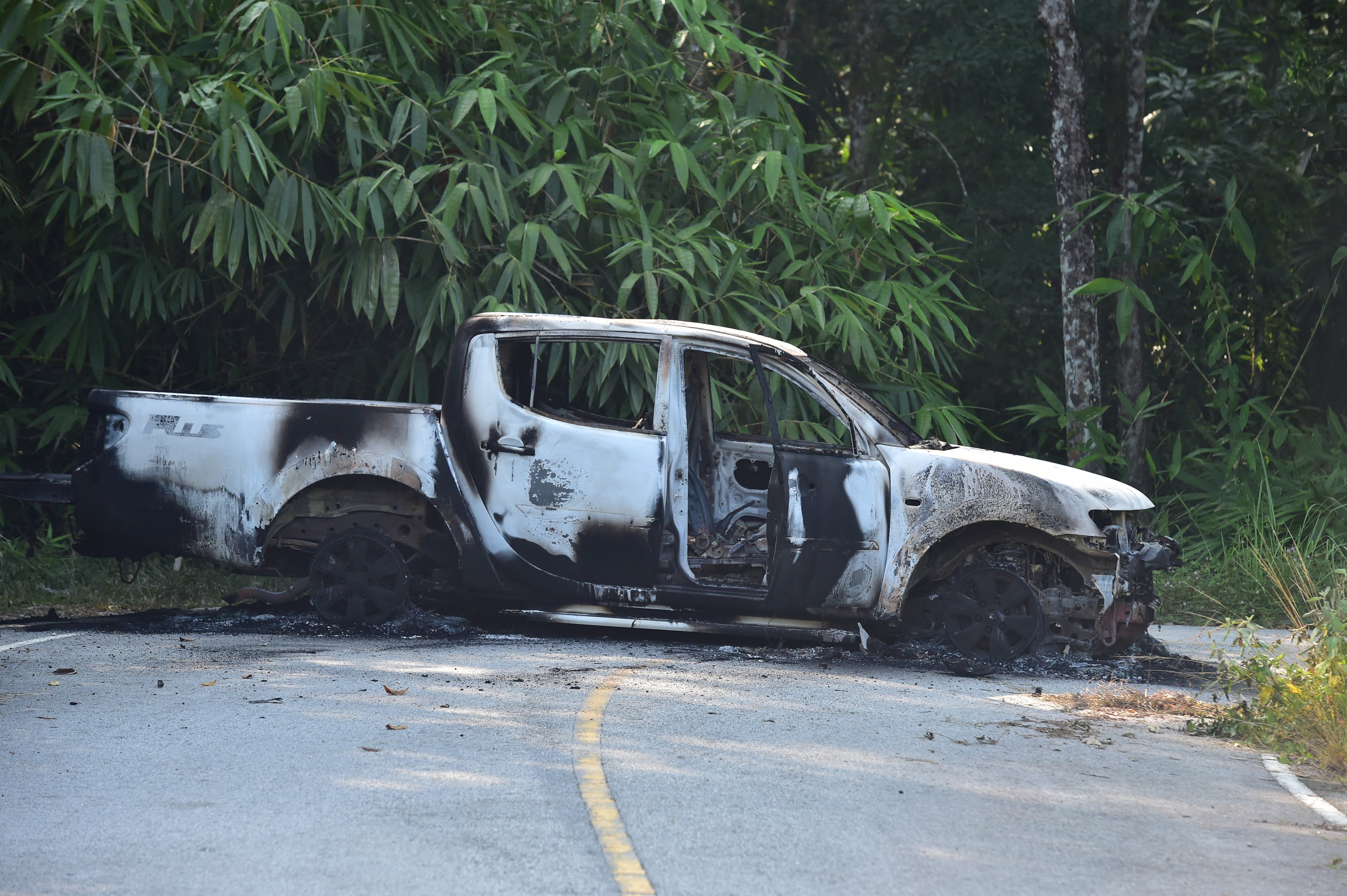 A charred vehicle is seen on a road in Ra-ngae district in the southern Thai province of Narathiwat