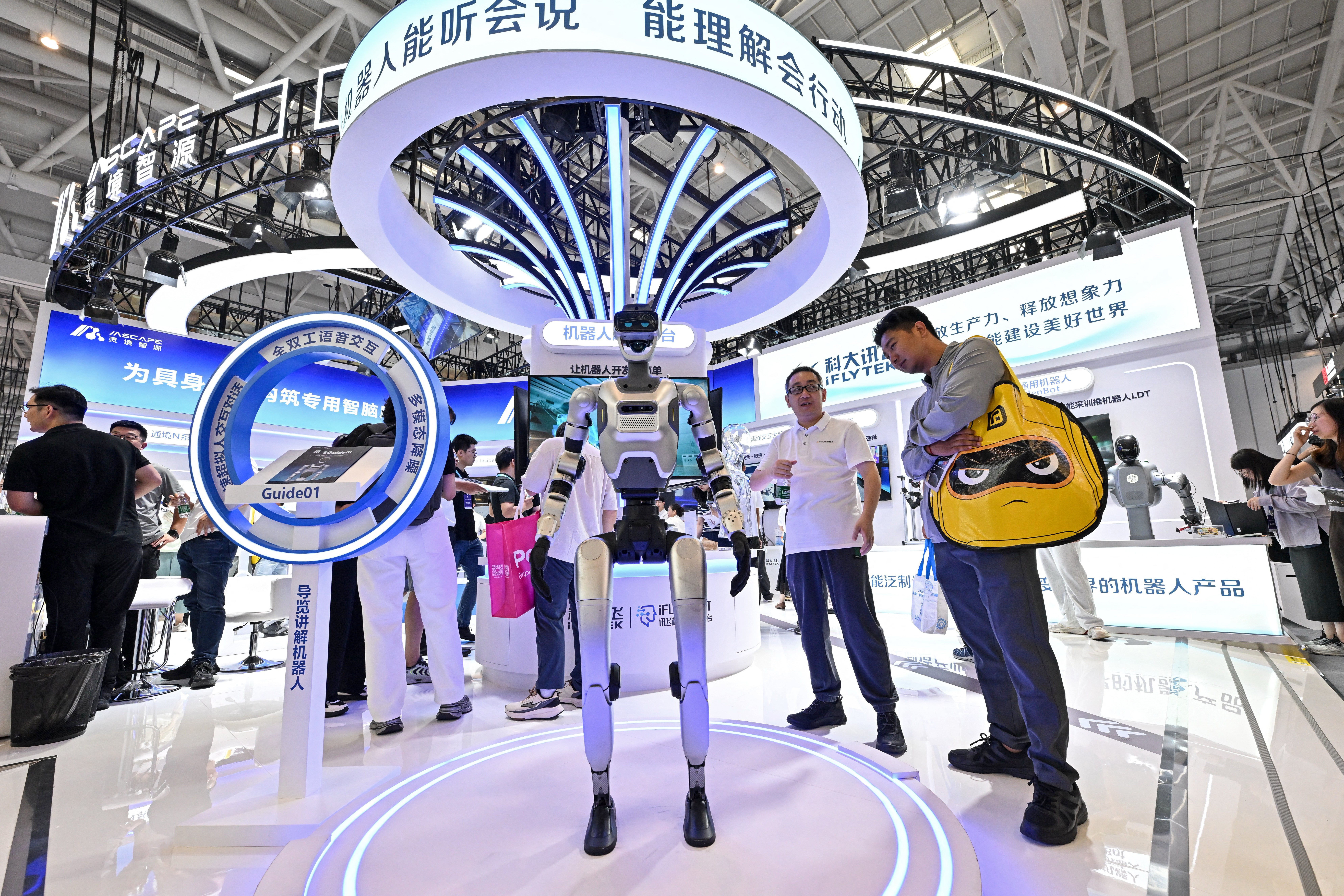People visit the stand of a humanoid robot (C) produced by iFLY AIBOT during the 2026 World Robot Conference in Beijing on August 20, 2026 (AFP/Getty)