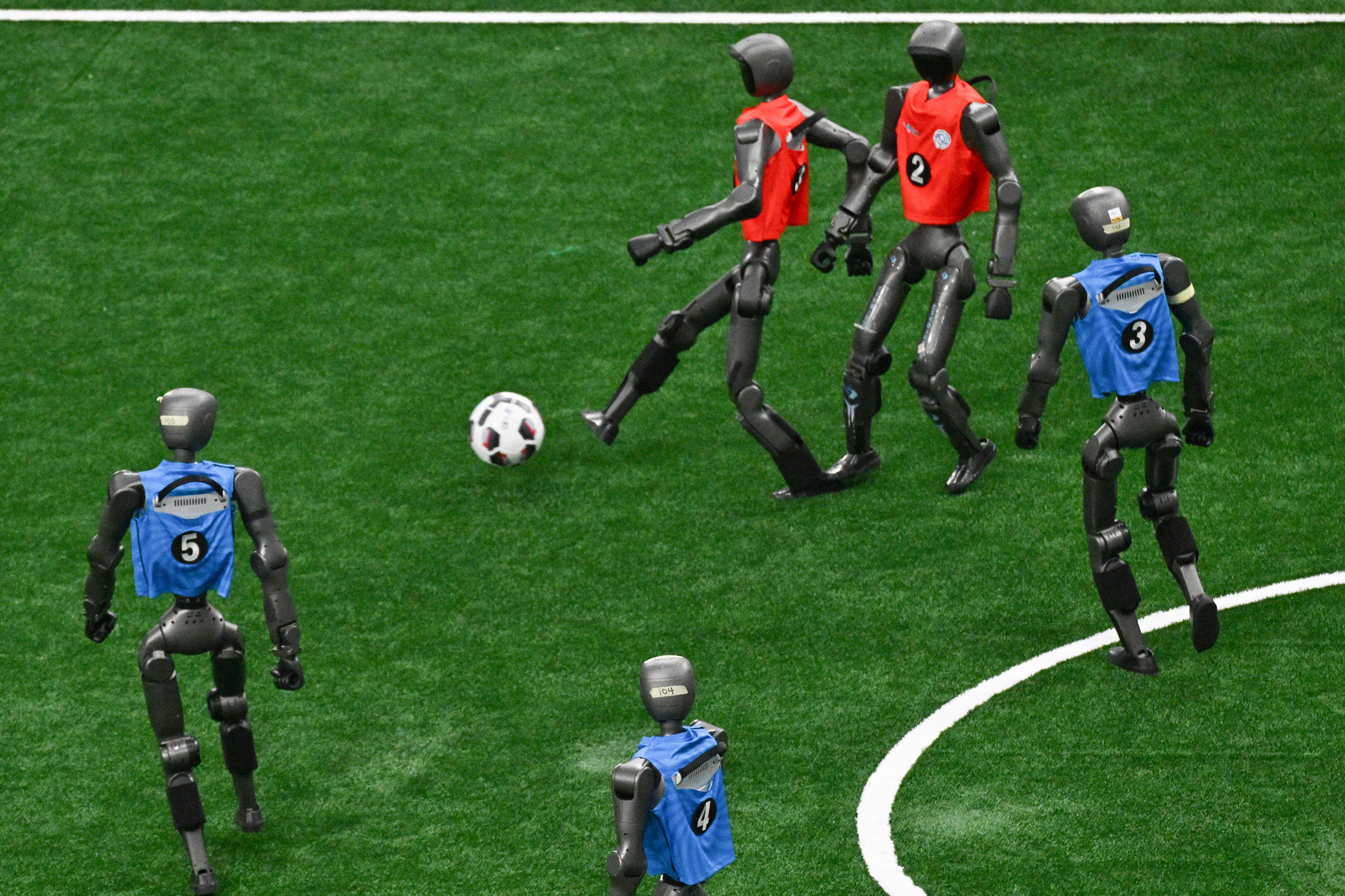 Humanoid robots vie for the ball during a football match at the 2nd World Humanoid Robot Games in Beijing on August 23, 2026. (Photo by Pedro PARDO / AFP via Getty Images) (AFP/Getty)