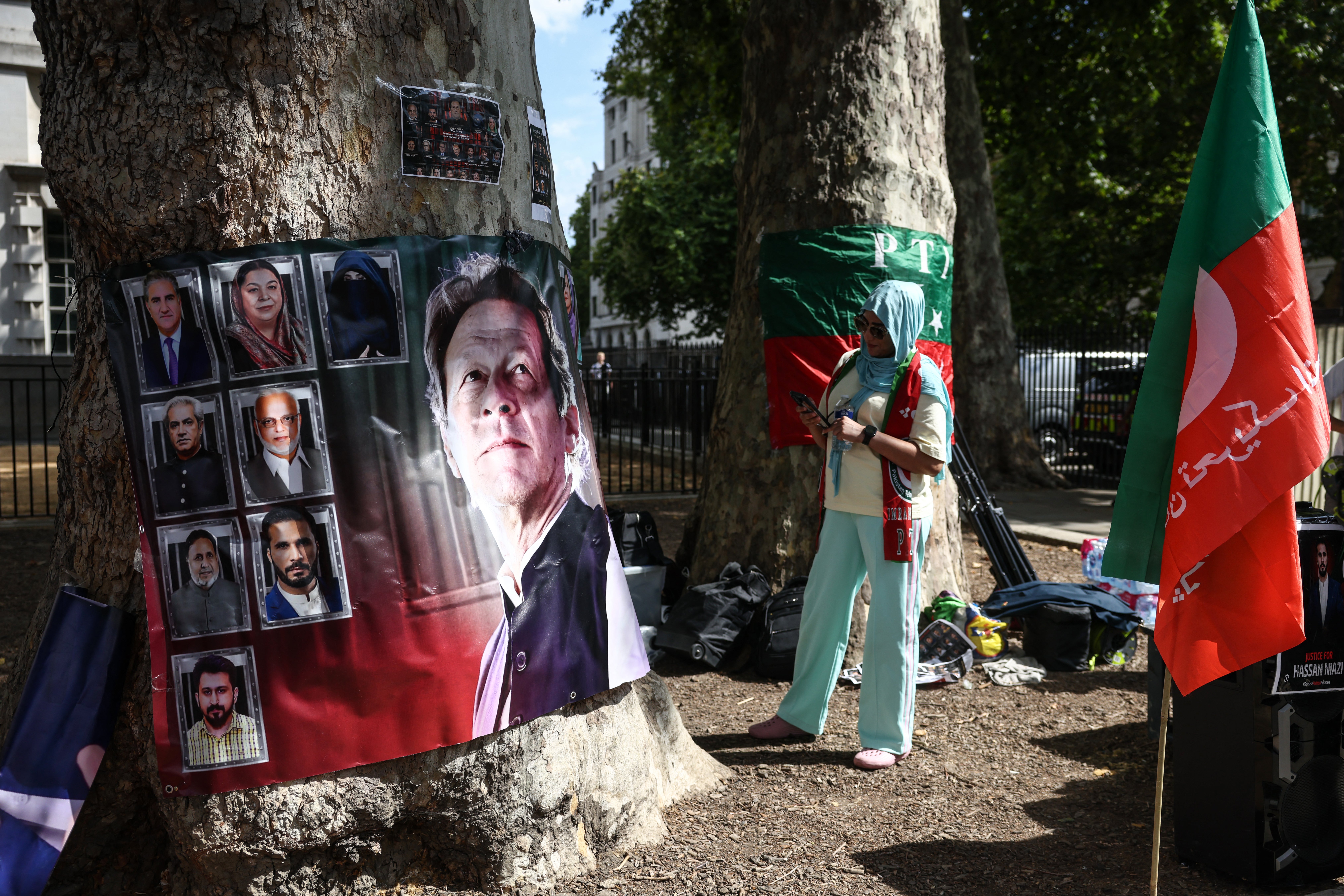 A woman looks at a banner showing Pakistan's jailed former prime minister Imran Khan