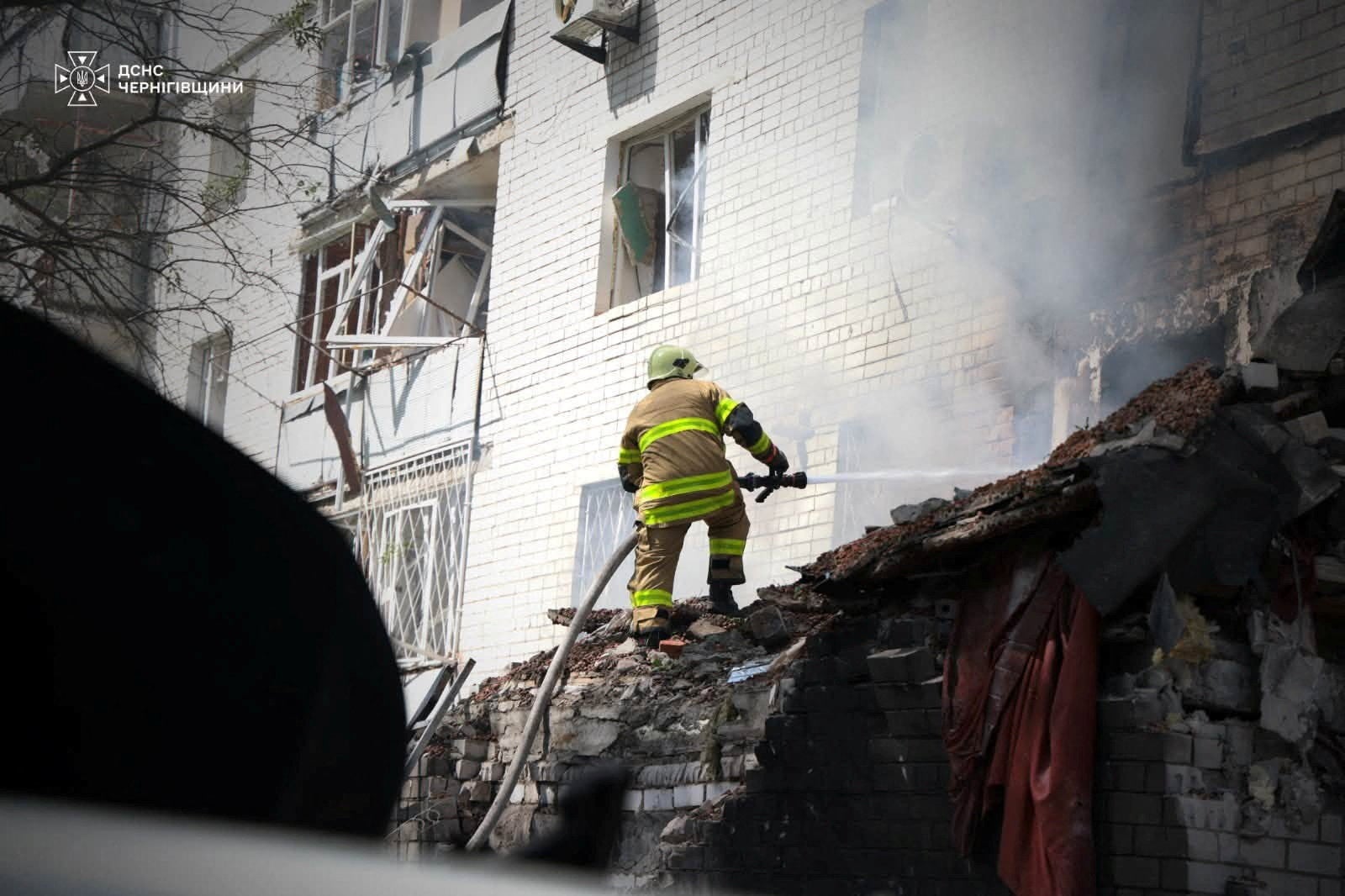 A firefighter works at the site of an apartment building hit by a Russian drone strike, amid Russia's attack on Ukraine, in Chernihiv