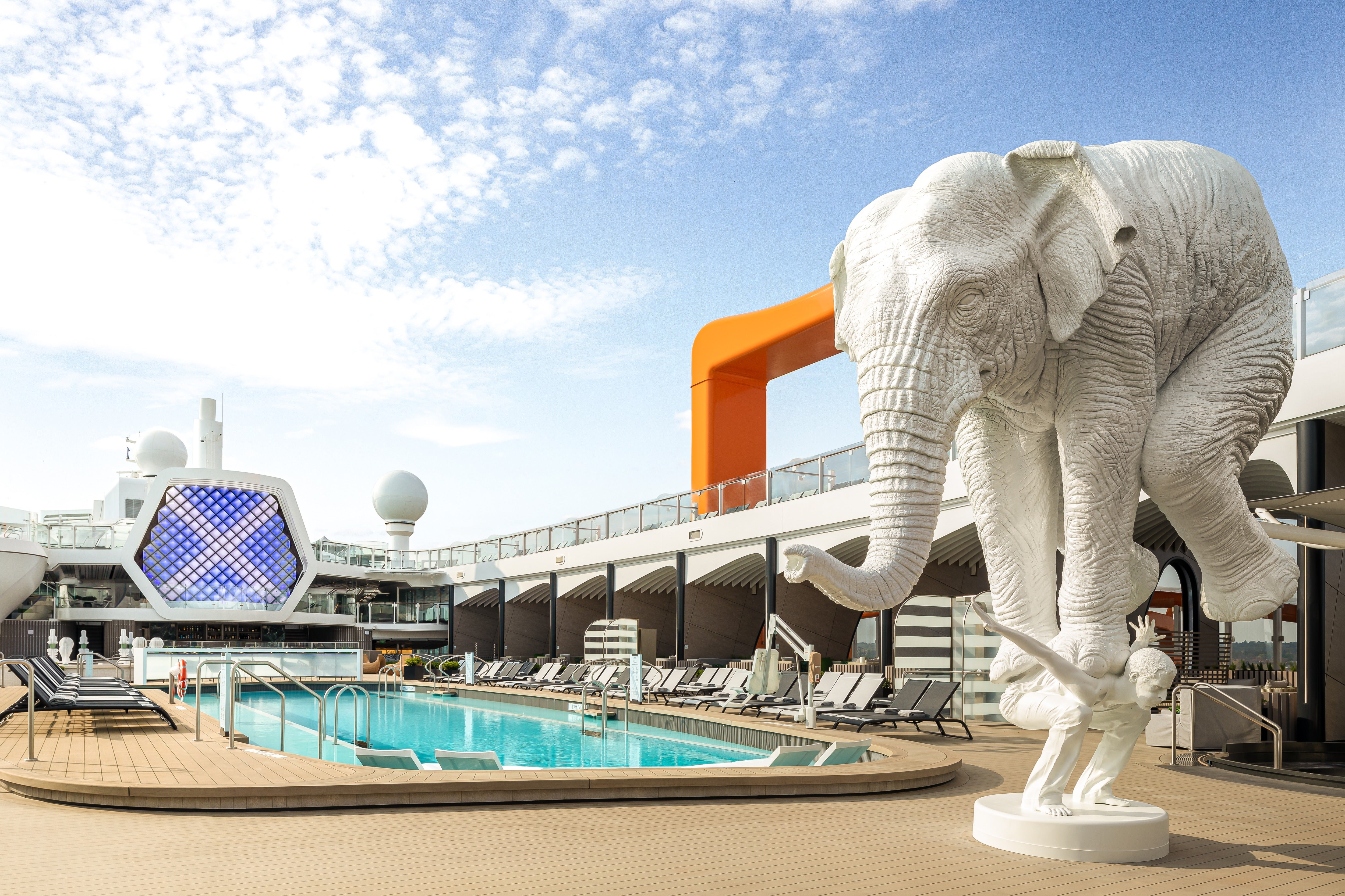 A sculpture of a large elephant balancing on top of a man is a key feature of Beyond's pool deck