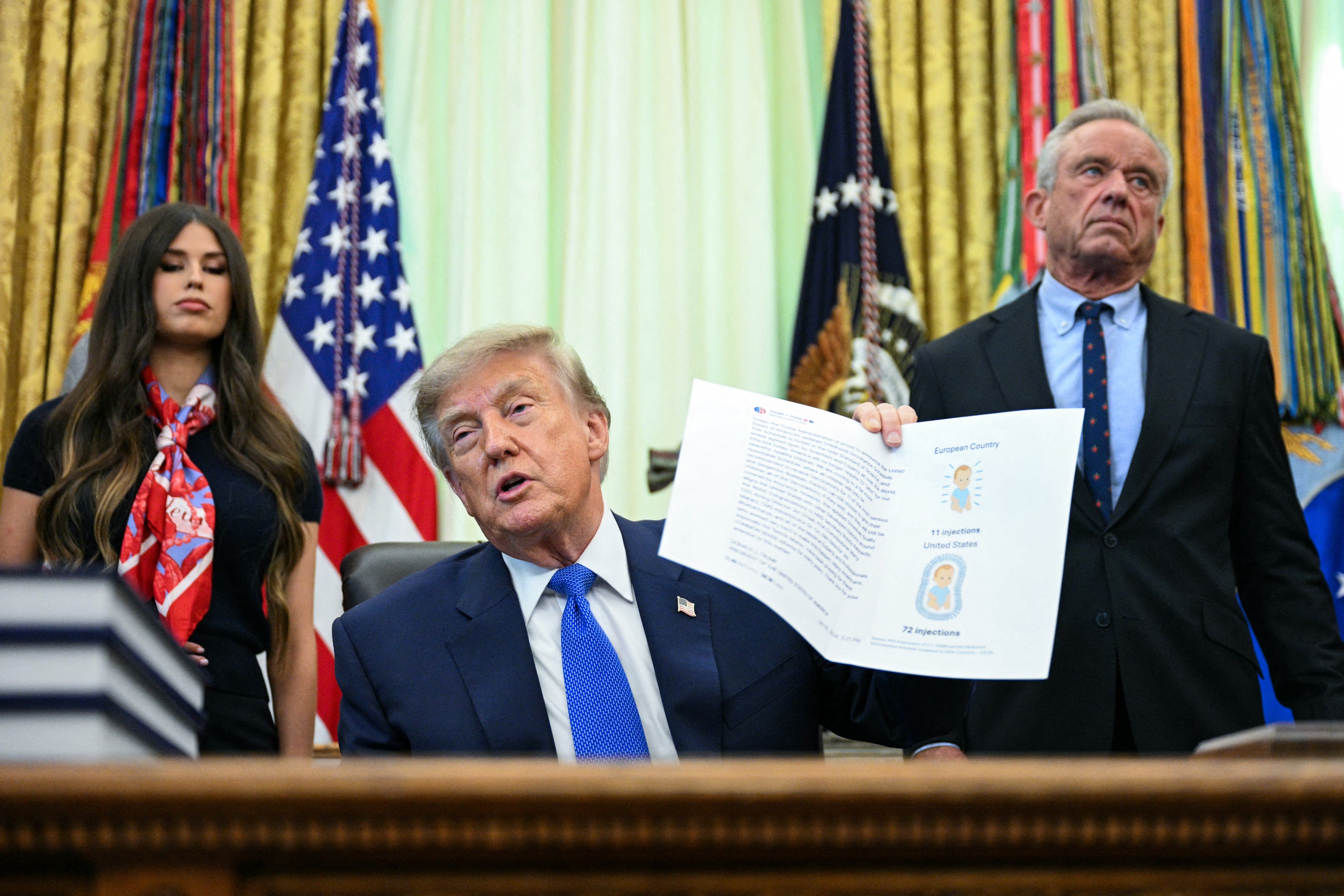 Health Sec. Robert F. Kennedy, Jr., right, looks on as President Donald Trump speaks at a signing of an executive order calling for more research and flexibility on vaccines at the White House earlier this month. Kennedy has also questioned the ties between vaccines and autism