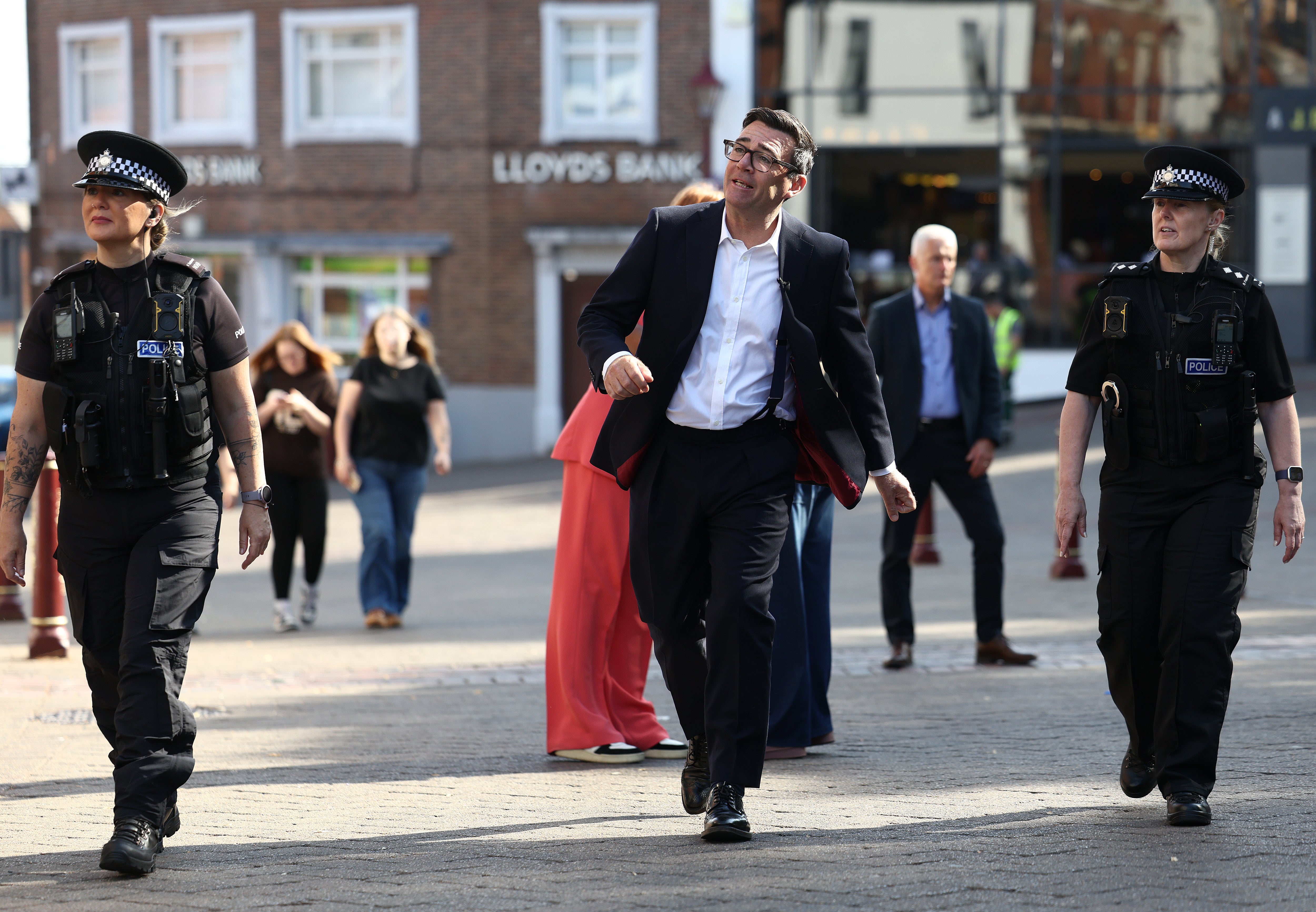 Prime Minister Andy Burnham seen with police officers as they walk past shops on August 11, 2026 in Ilkeston, England