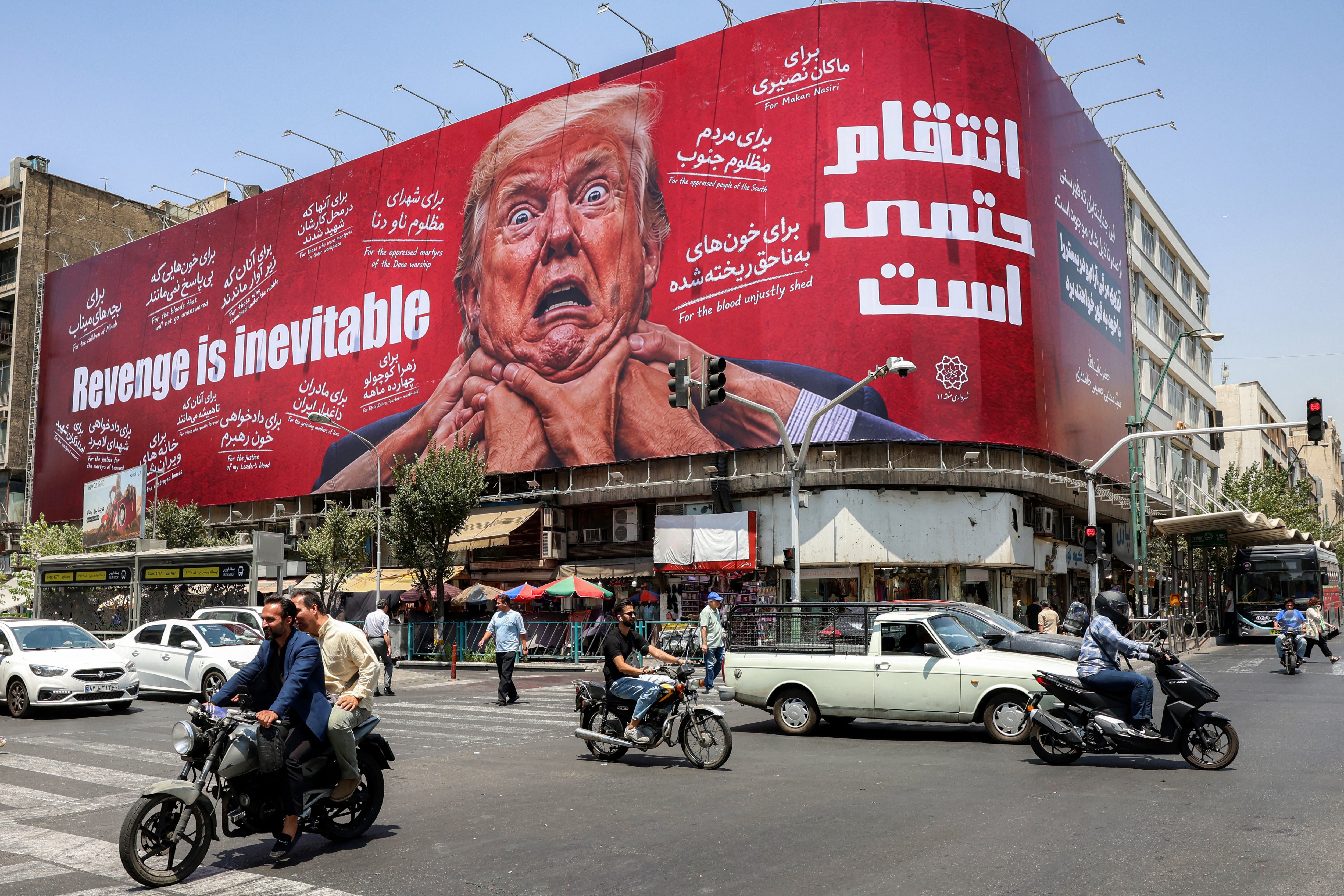 Motorists drive past a large billboard pledging revenge against President Donald Trump in central Tehran on July 27