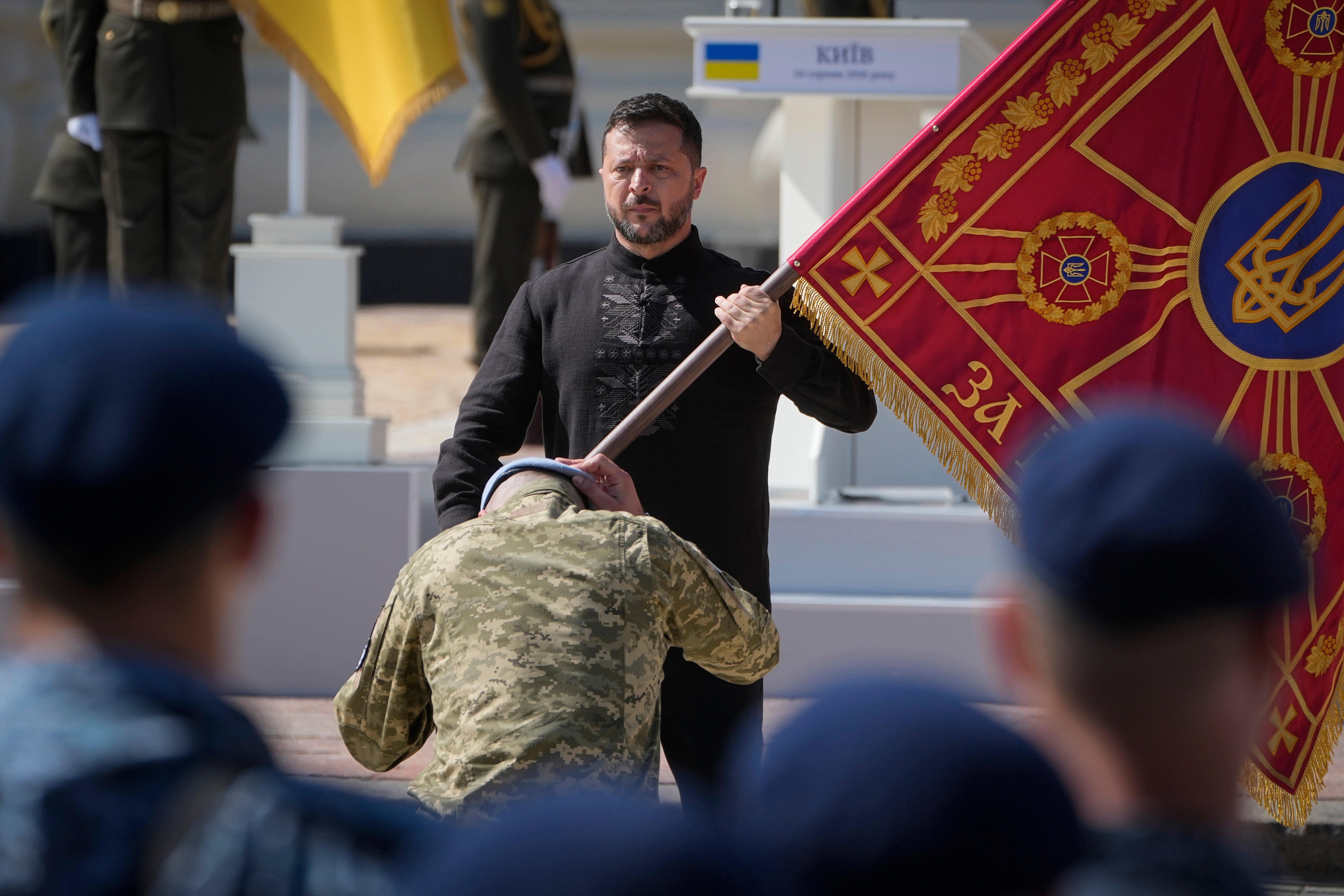 Ukraine's President Volodymyr Zelenskyy hands over the flag of a military unit during the ceremony to mark Ukraine Independence Day in Kyiv