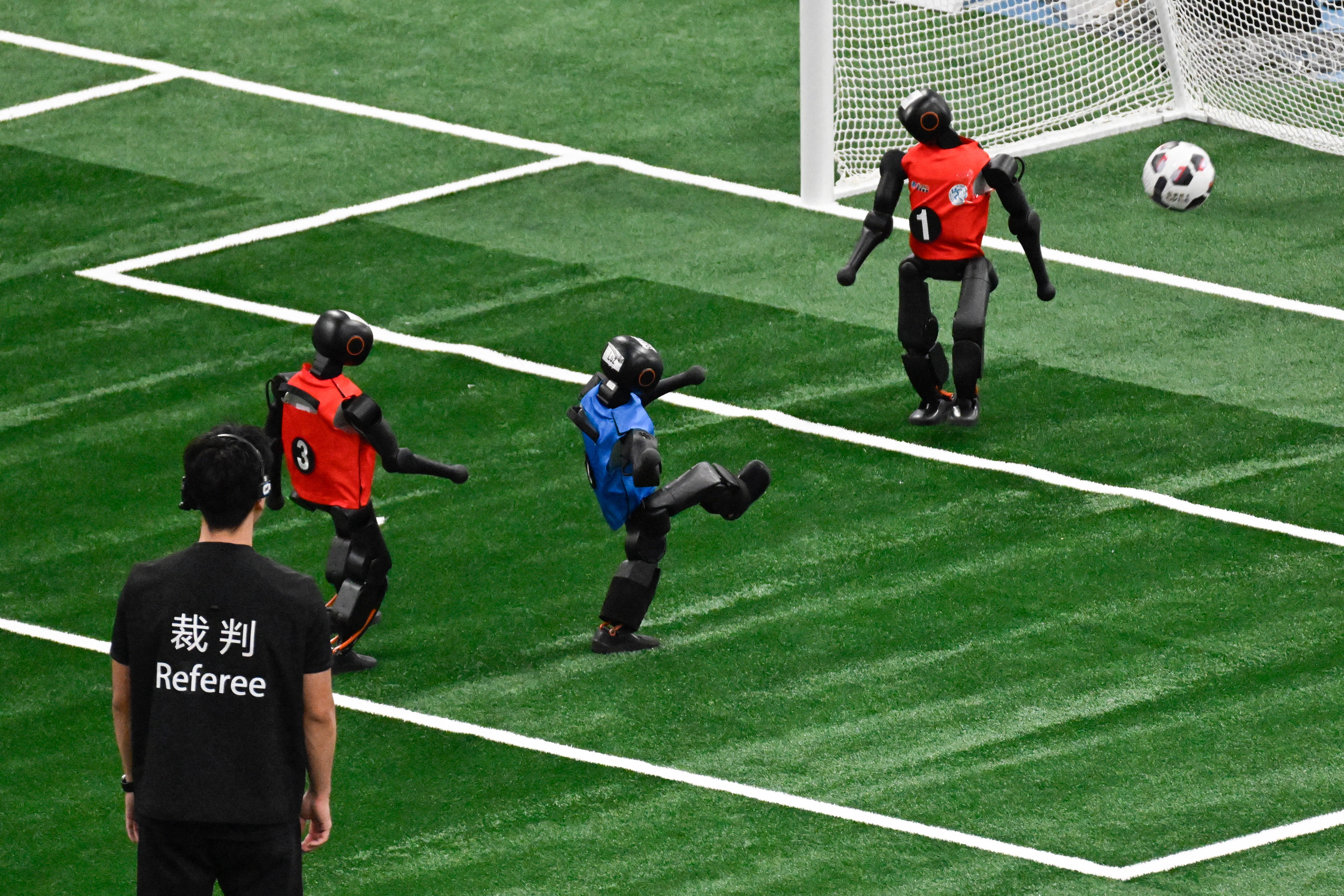 A humanoid robot takes a shot during a football match at the 2nd World Humanoid Robot Games