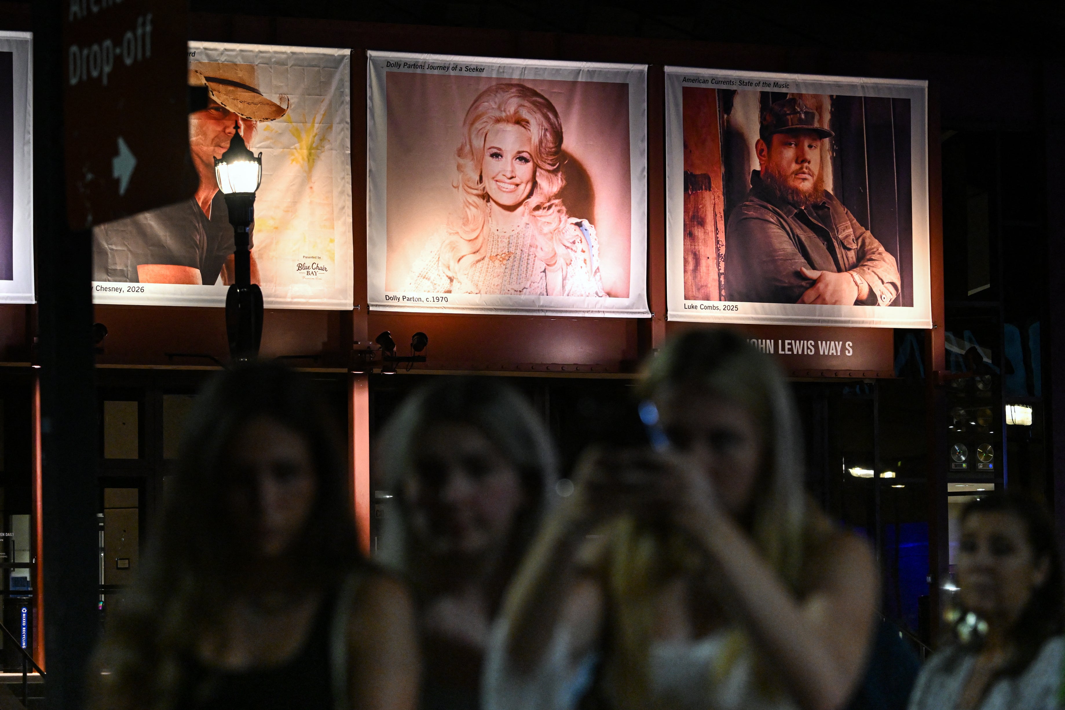 Fans gather near a photo of the late US singer-songwriter Dolly Parton displayed at the Country Music Hall of Fame and Museum in Nashville, Tennessee