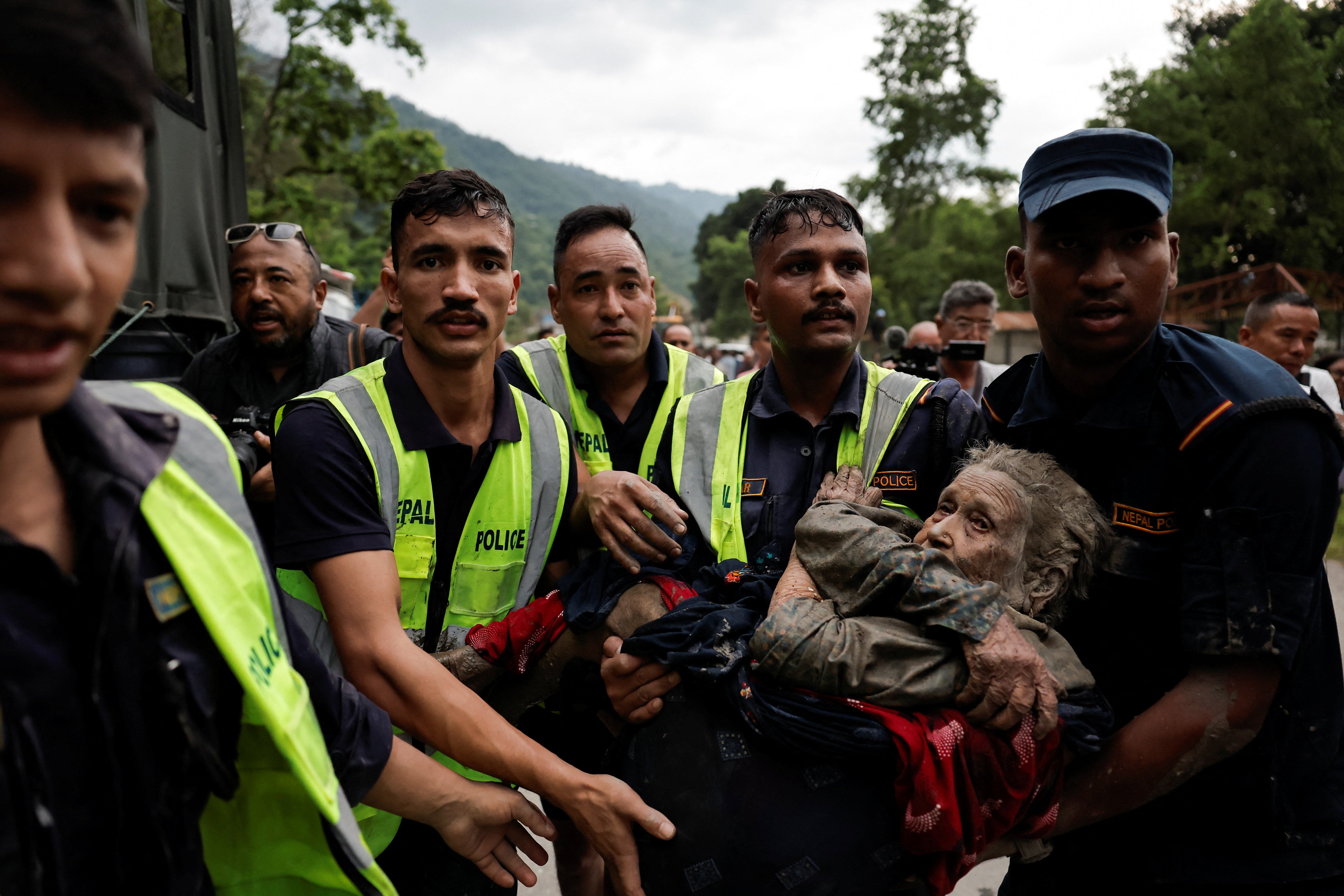 Police officers carry a survivor to a safer place following a flash flood at Trishuli in Nuwakot district, Nepal.