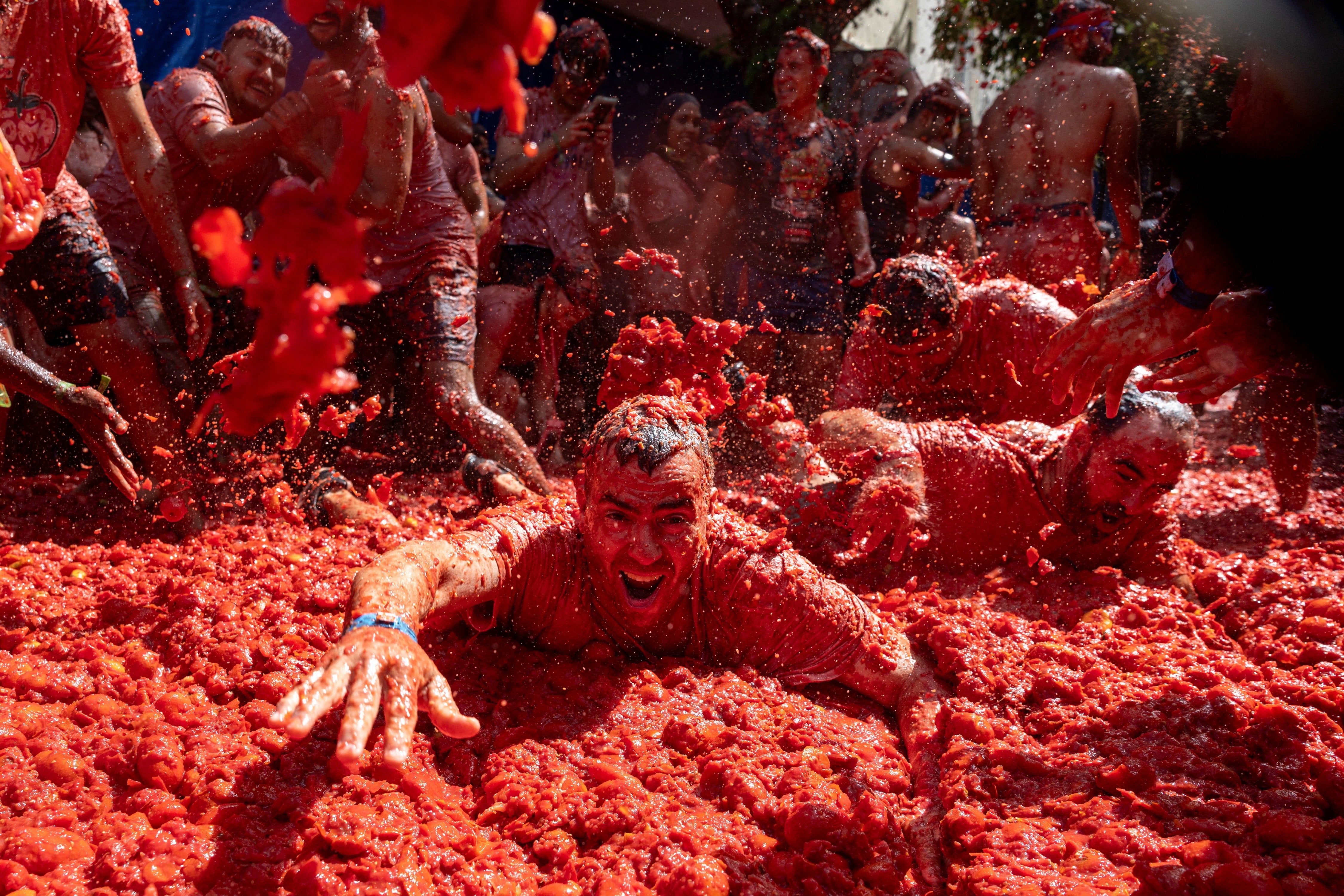 People bath in tomatoes during the annual 
