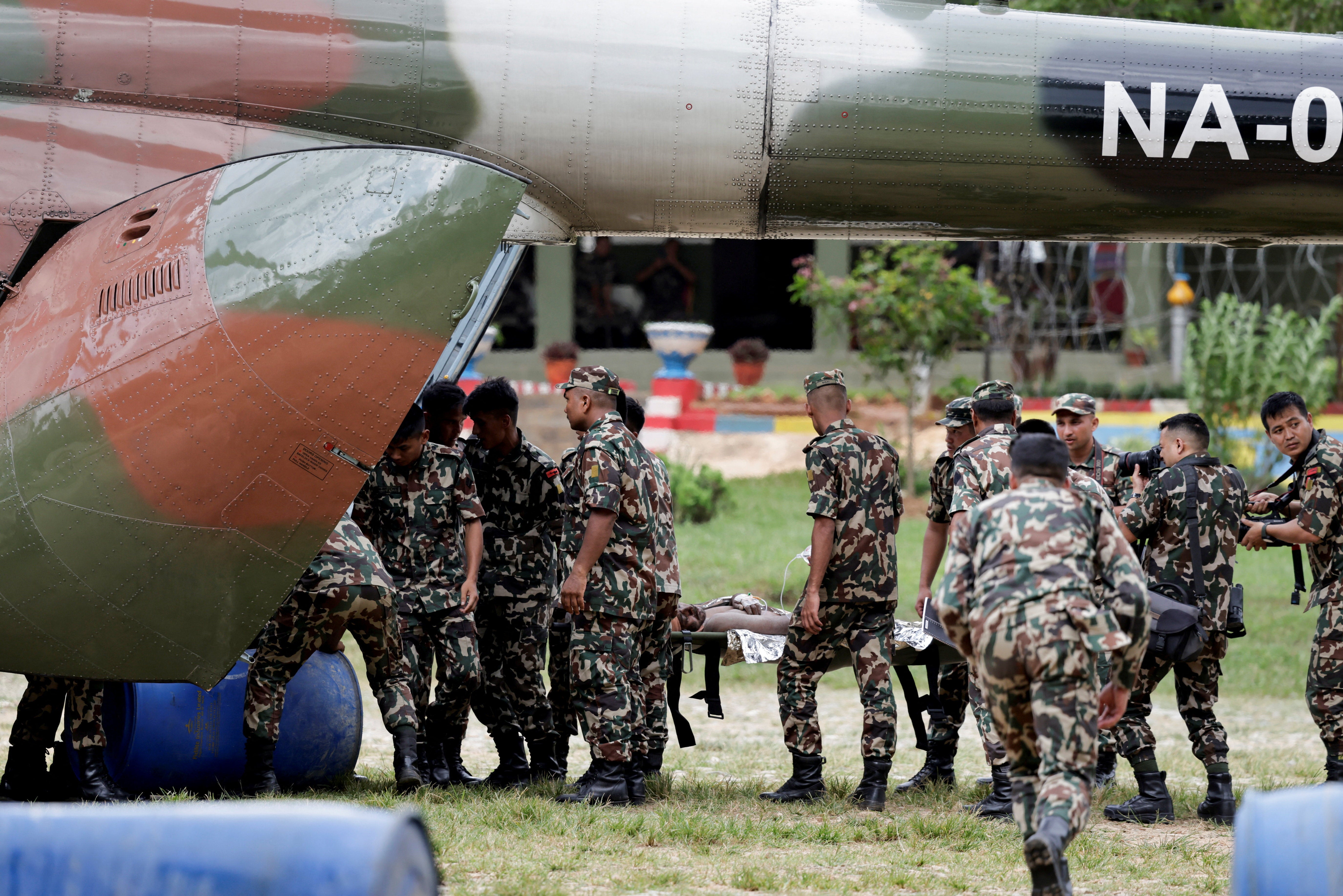 Members of the Nepali Army carry a survivor who was being airlifted (Reuters)