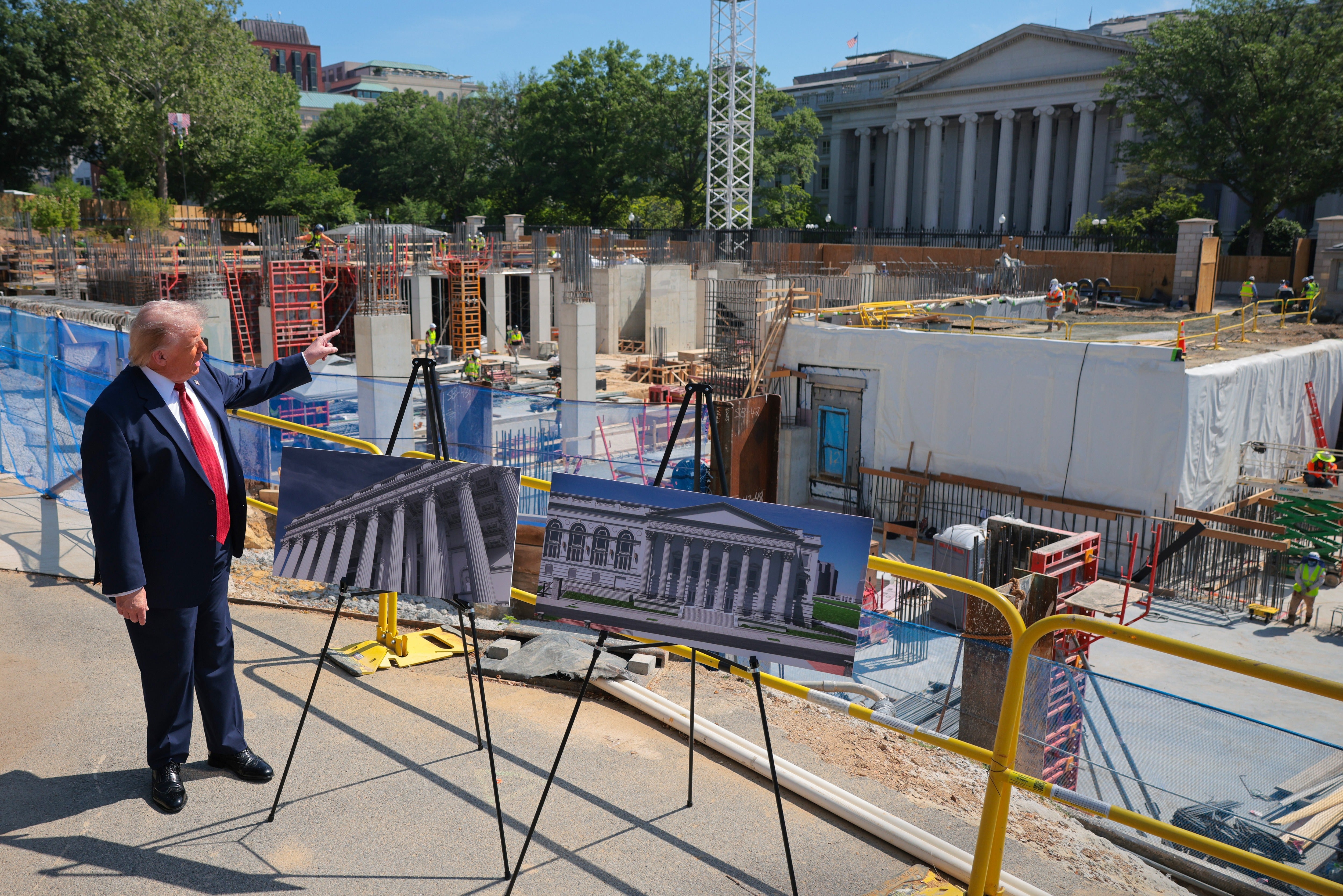 President Donald Trump speaks to the media alongside posters of his proposed White House ballroom amid construction at the White House May 19