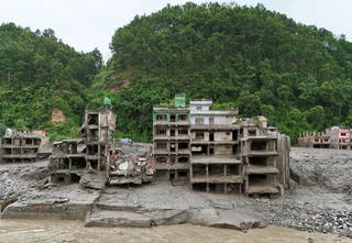 A drone view shows mud covering properties following a flash flood in Trishuli