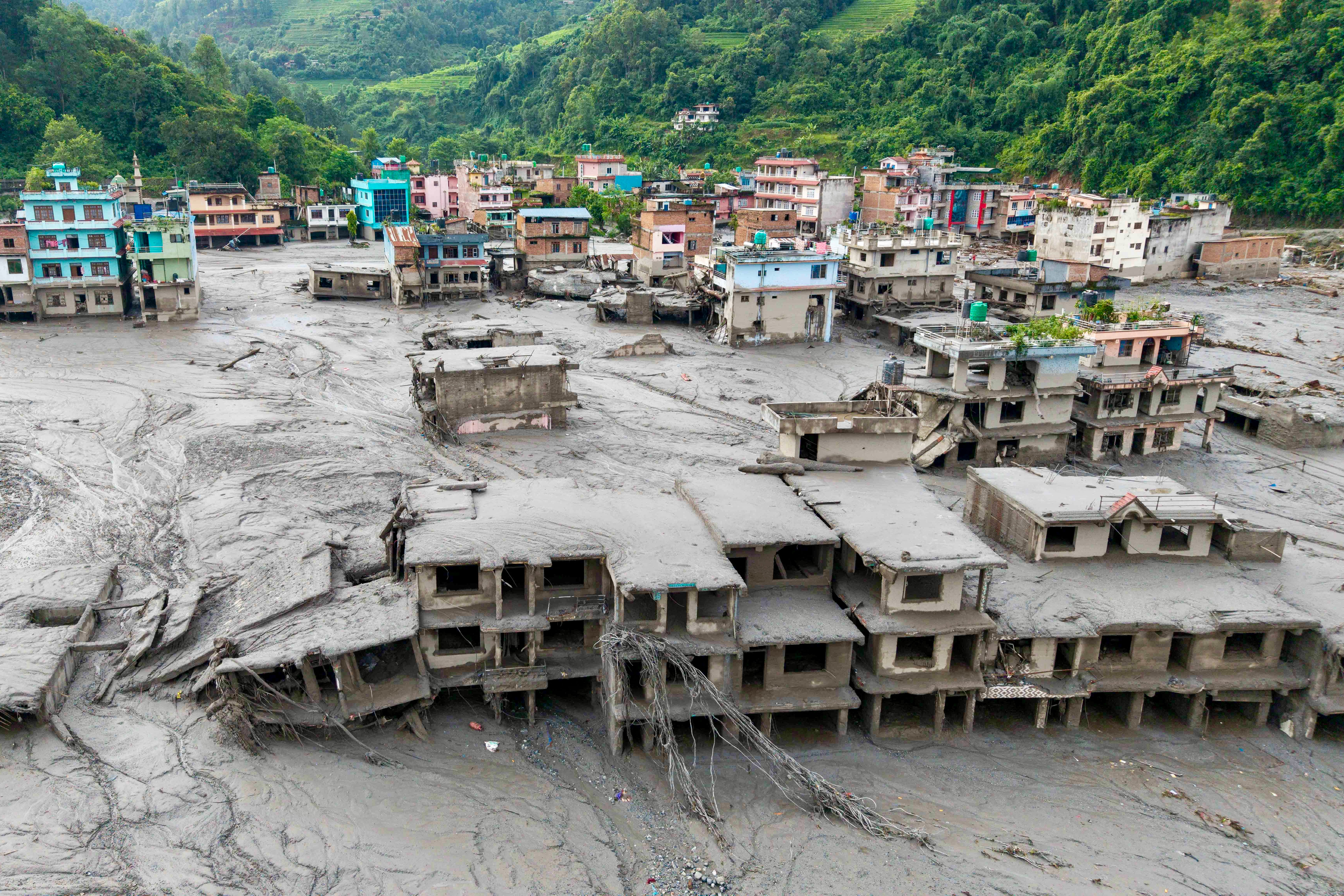 An aerial view shows houses lying deluged in sludge after flash floods at Devighat, Bidur Municipality in Nepal's Nuwakot district on 27 August 2026