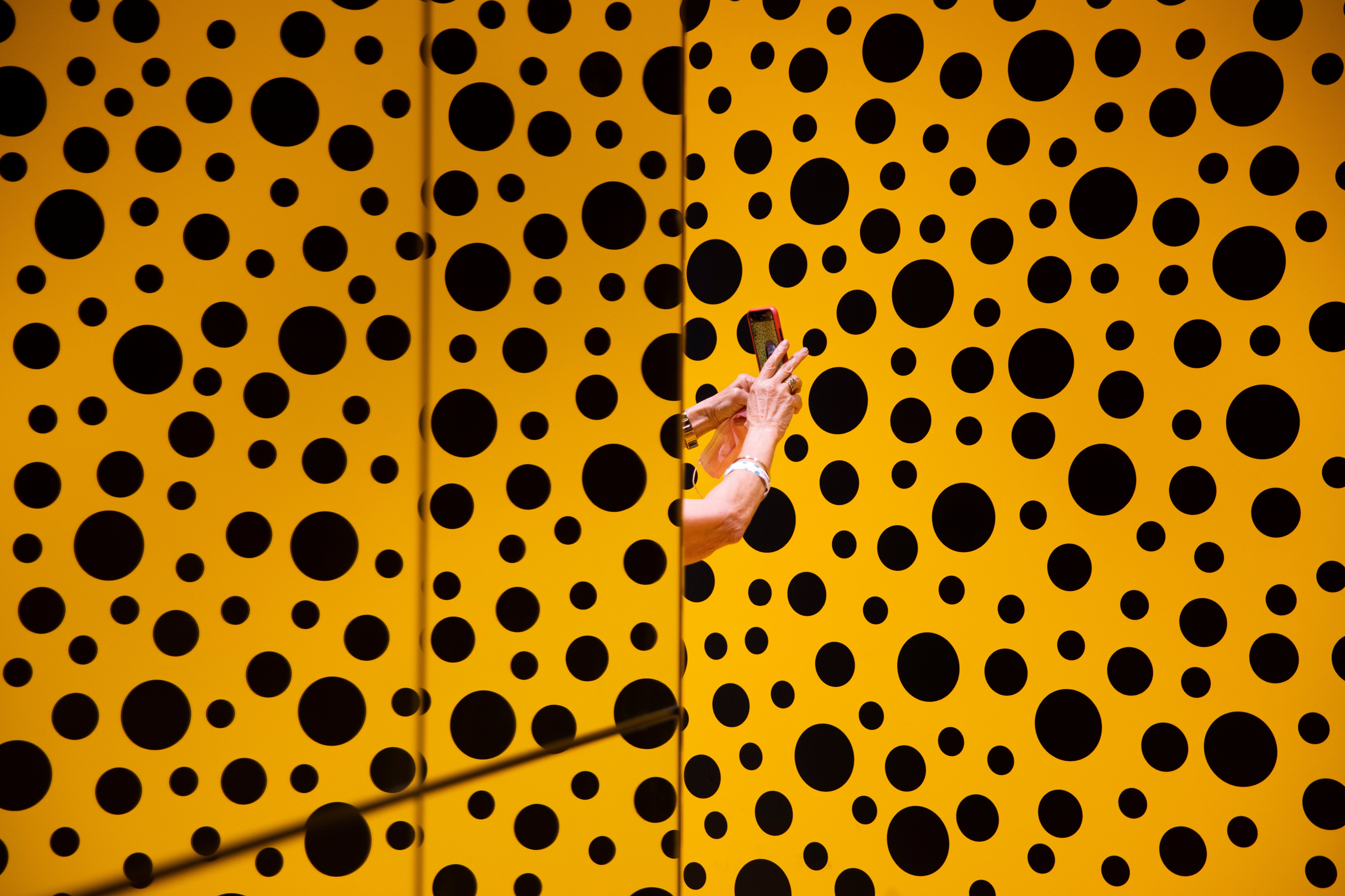 A woman takes a photo during her visit at the art work 'The Spirits of the Pumpkins Descended into the Heavens' by Yayoi Kusama. (Copyright 2021 The Associated Press. All rights reserved)
