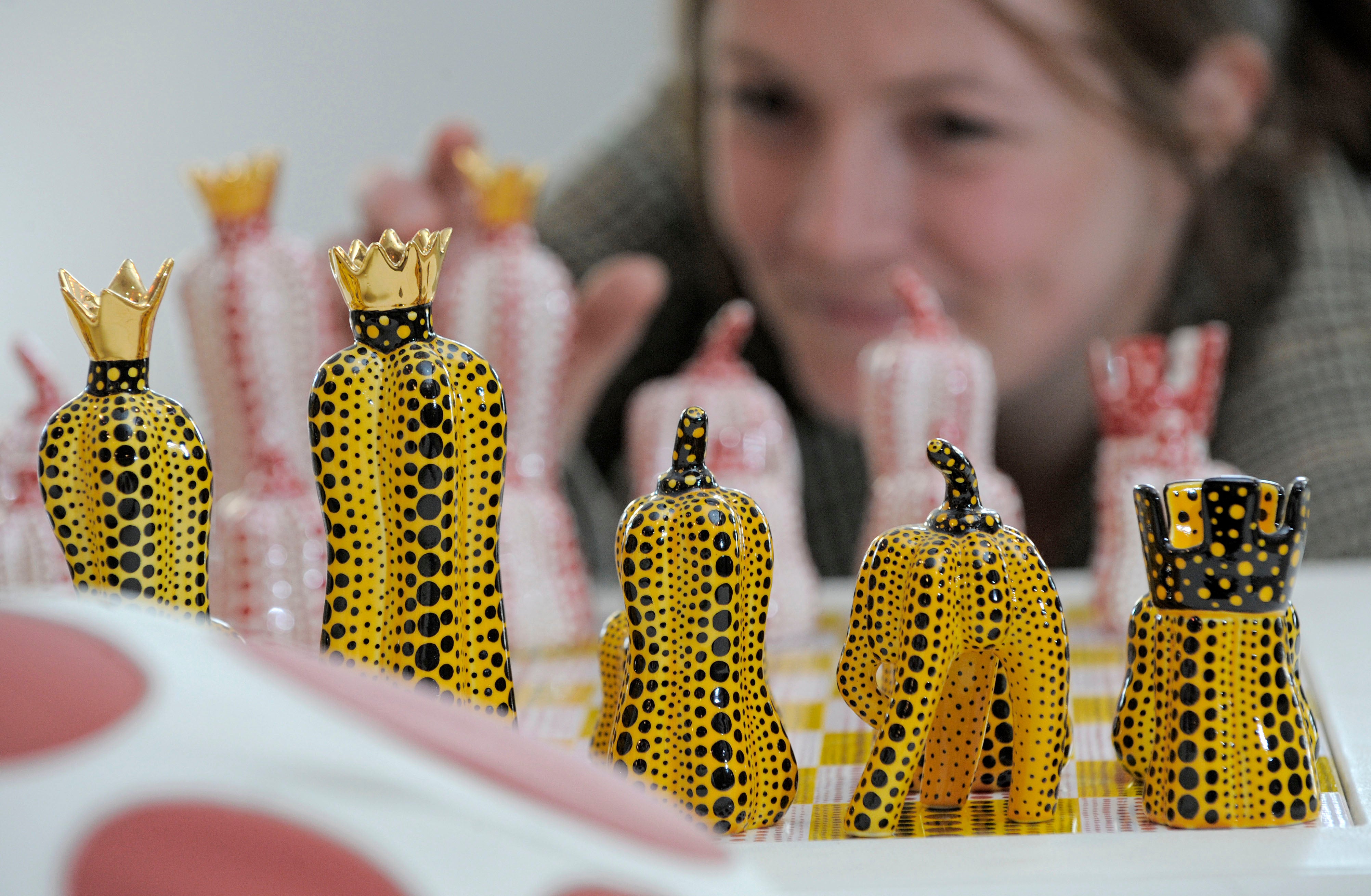 Exhibition assistant Kathrin DuBois of the Museum Ludwig in Cologne arranges chess board figures of the installation 'Pumpkin Chess' in the Porzellanikon Museum in Selb, southern Germany. (2010 AP)
