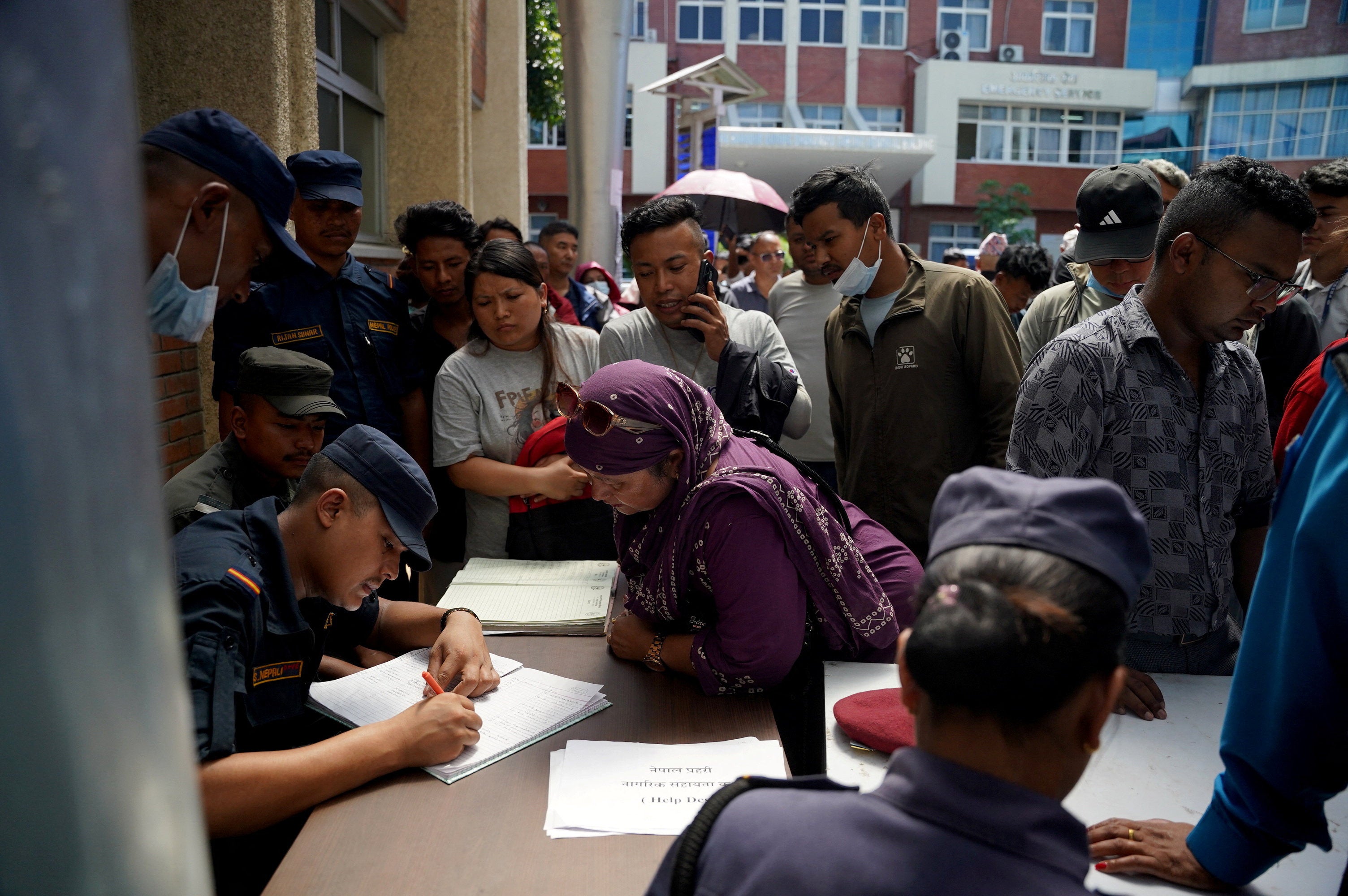 Family members gather in a hospital to check list of injured people following deadly floods, in Kathmandu, Nepal, 27 August 2026