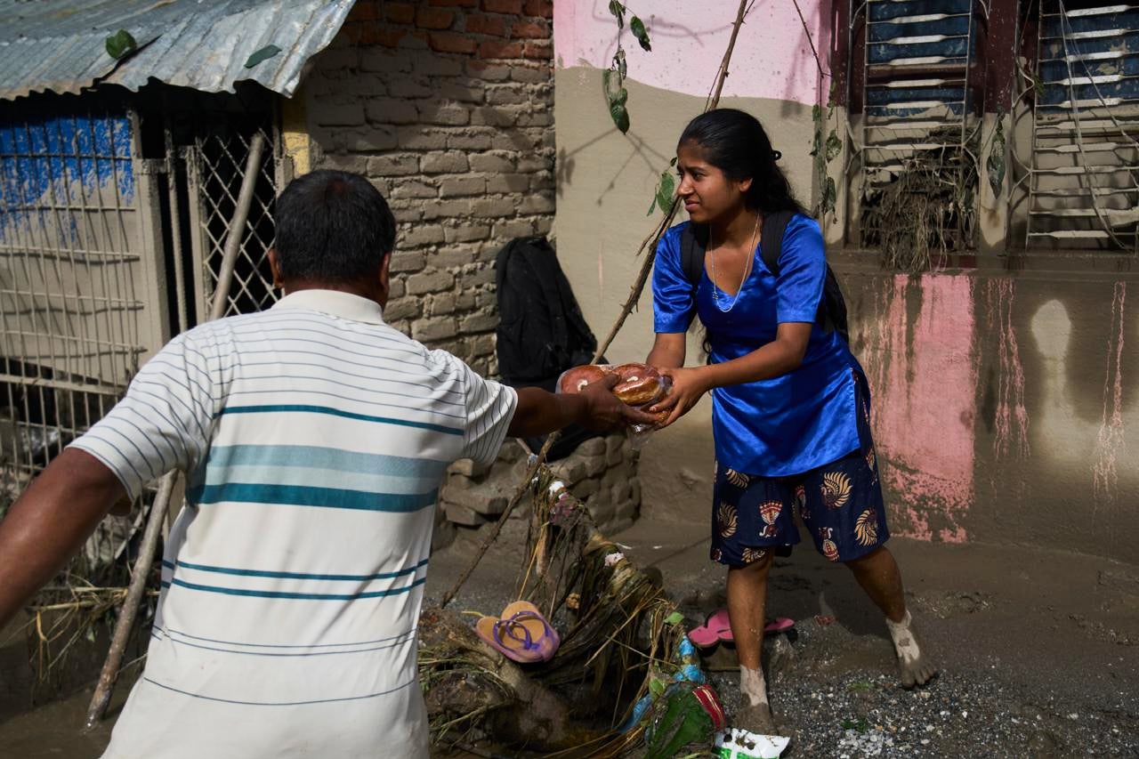 A girl collects food in the aftermath of flash floods in Devighat in the Nuwakot district in Nepal, Thursday, Aug 27, 2026