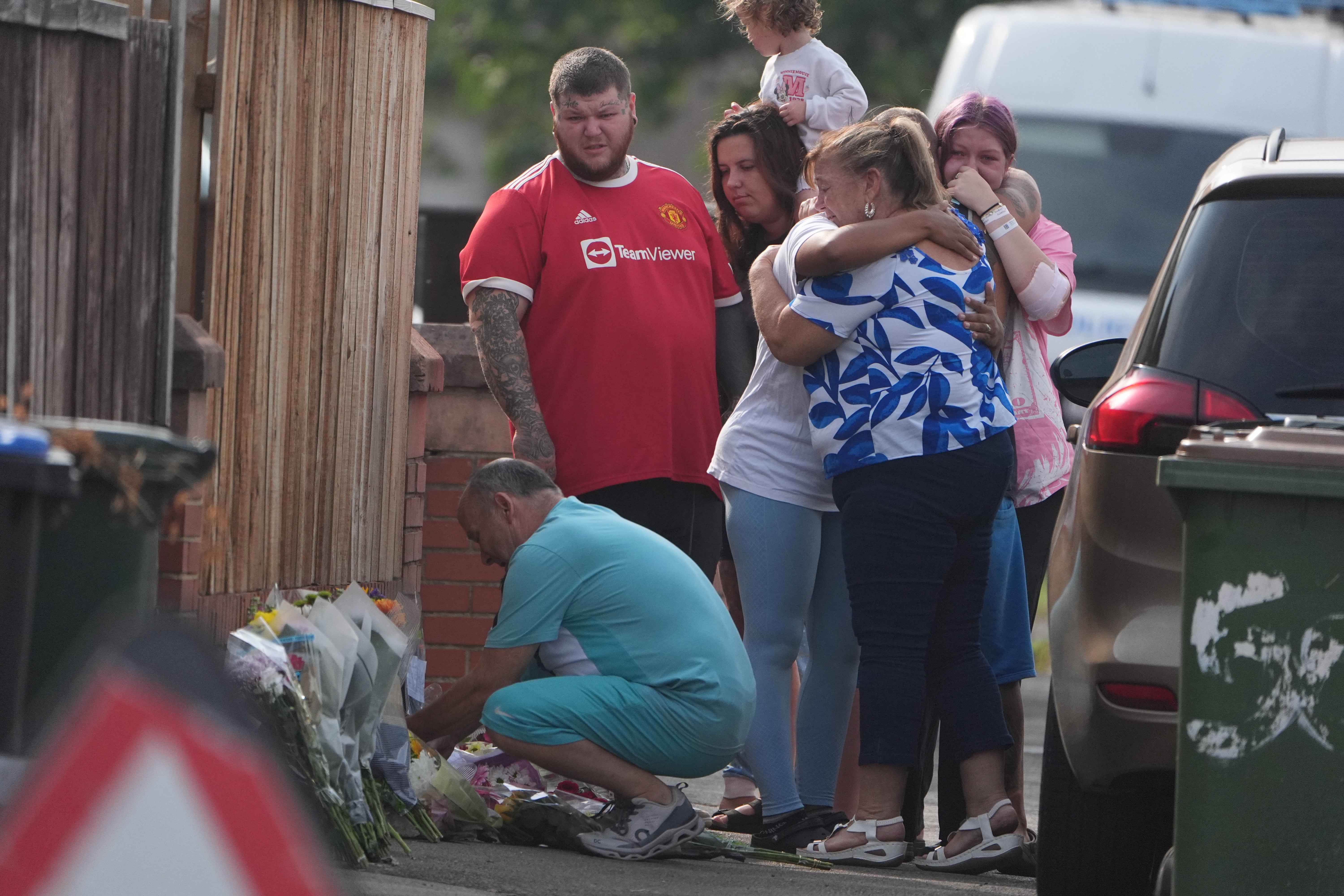 People lay flowers at the scene on Birchington Avenue, Grangetown, where a 7-year-old girl and her aunt died in a house fire