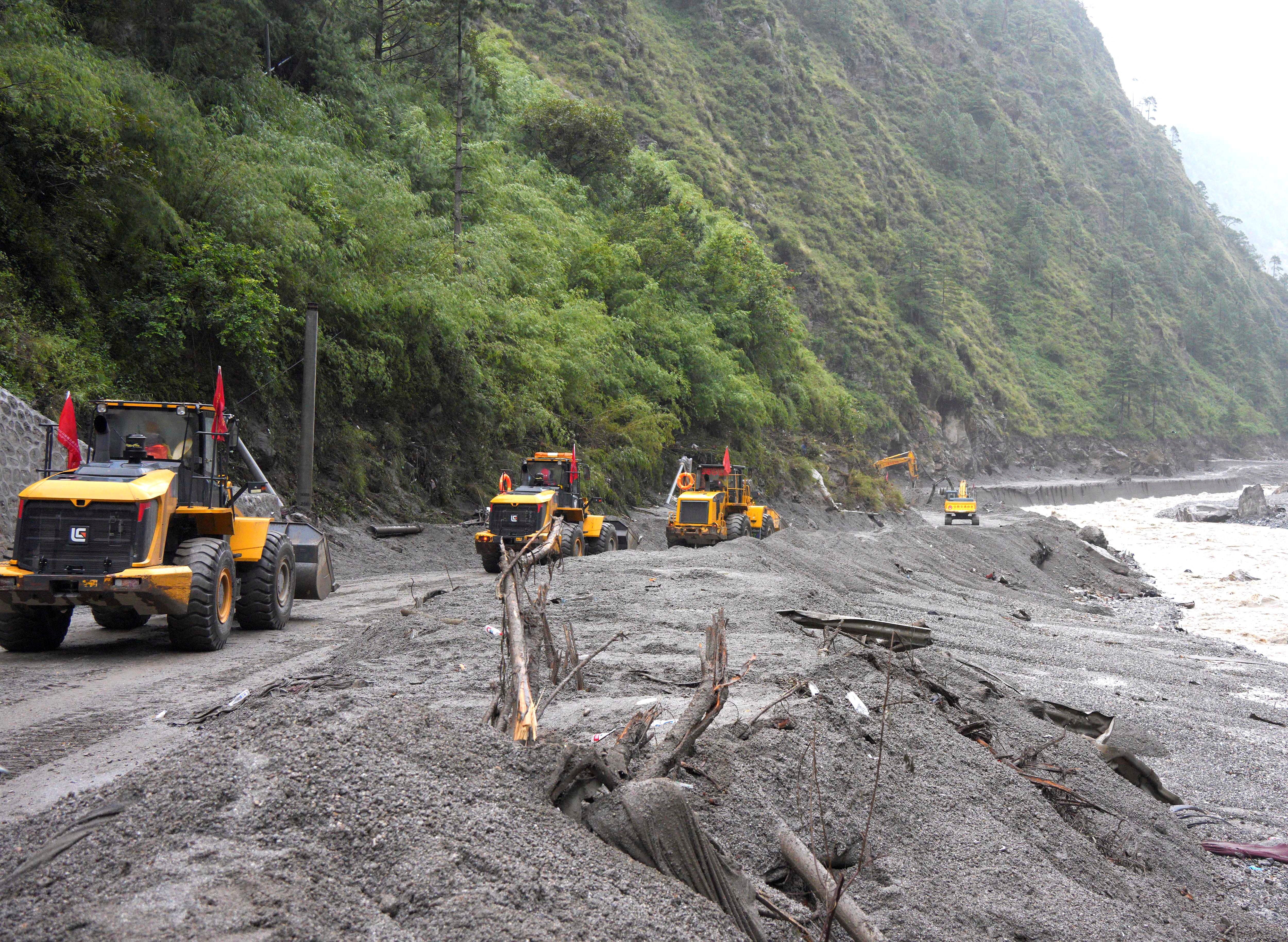 Rescue workers repair a road leading to Gyirong Port after a mudslide