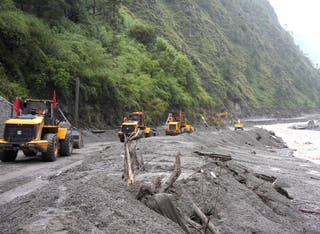 Rescue workers repair a road leading to Gyirong Port after a mudslide