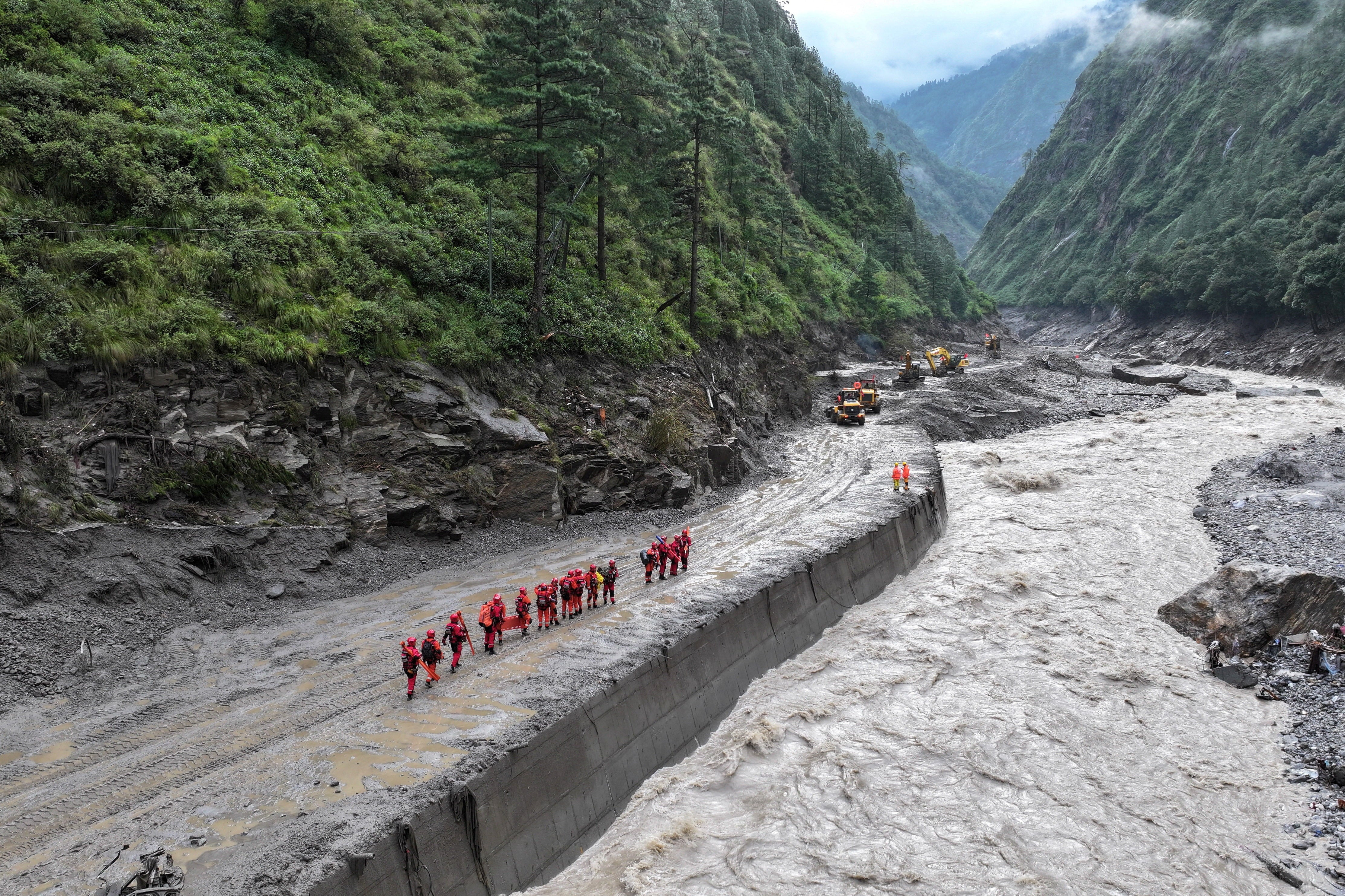 Firefighters during a search and rescue operation along a damaged road leading to the Gyirong port in the Shigatse area of Tibet, China (Reuters)