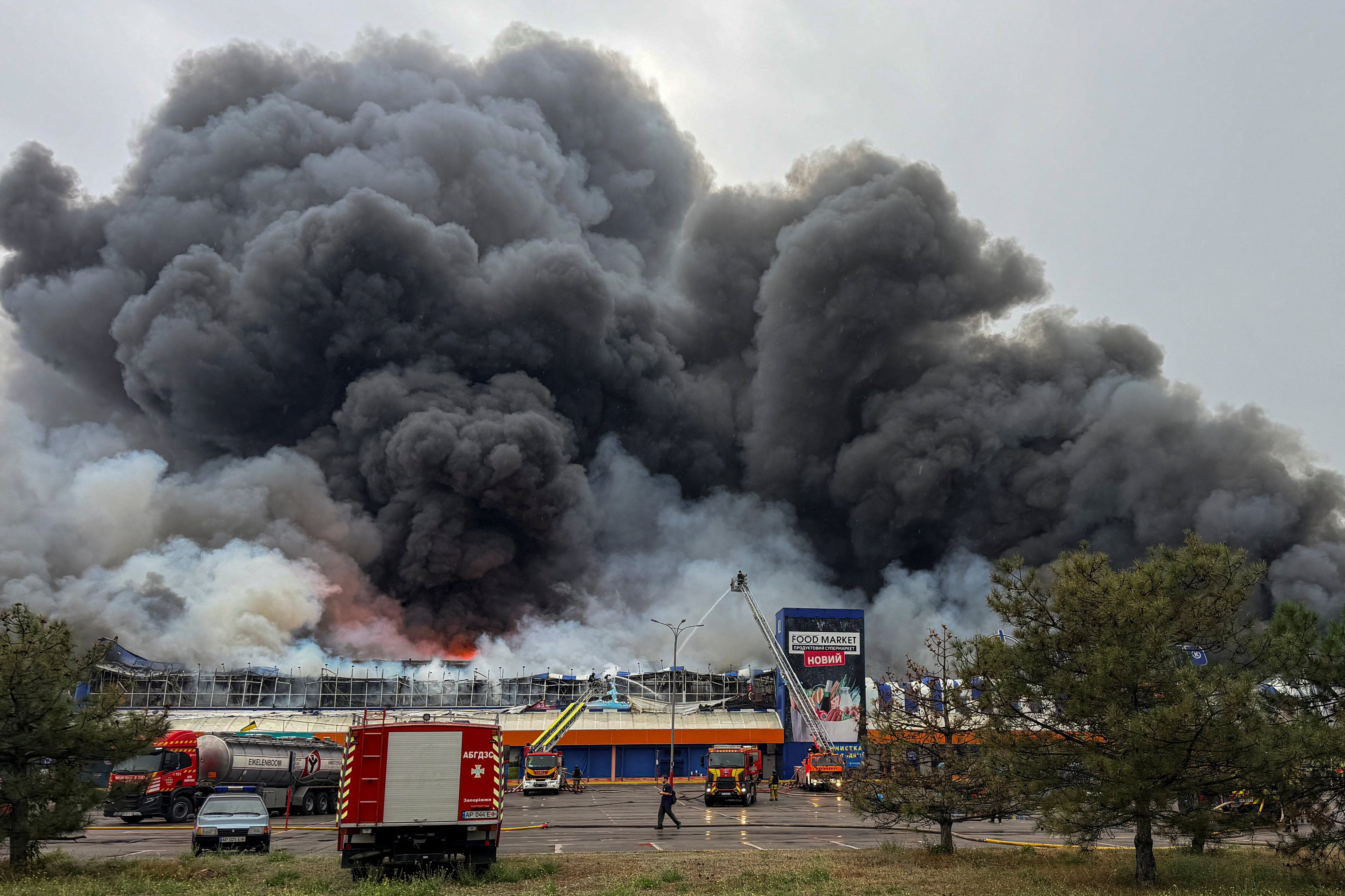 Firefighters work at the site of a household and construction item shopping mall, as smoke and fire rise after Russian drone strikes, amid Russia's attack on Ukraine, in Zaporizhzhia, Ukraine August 28, 2026