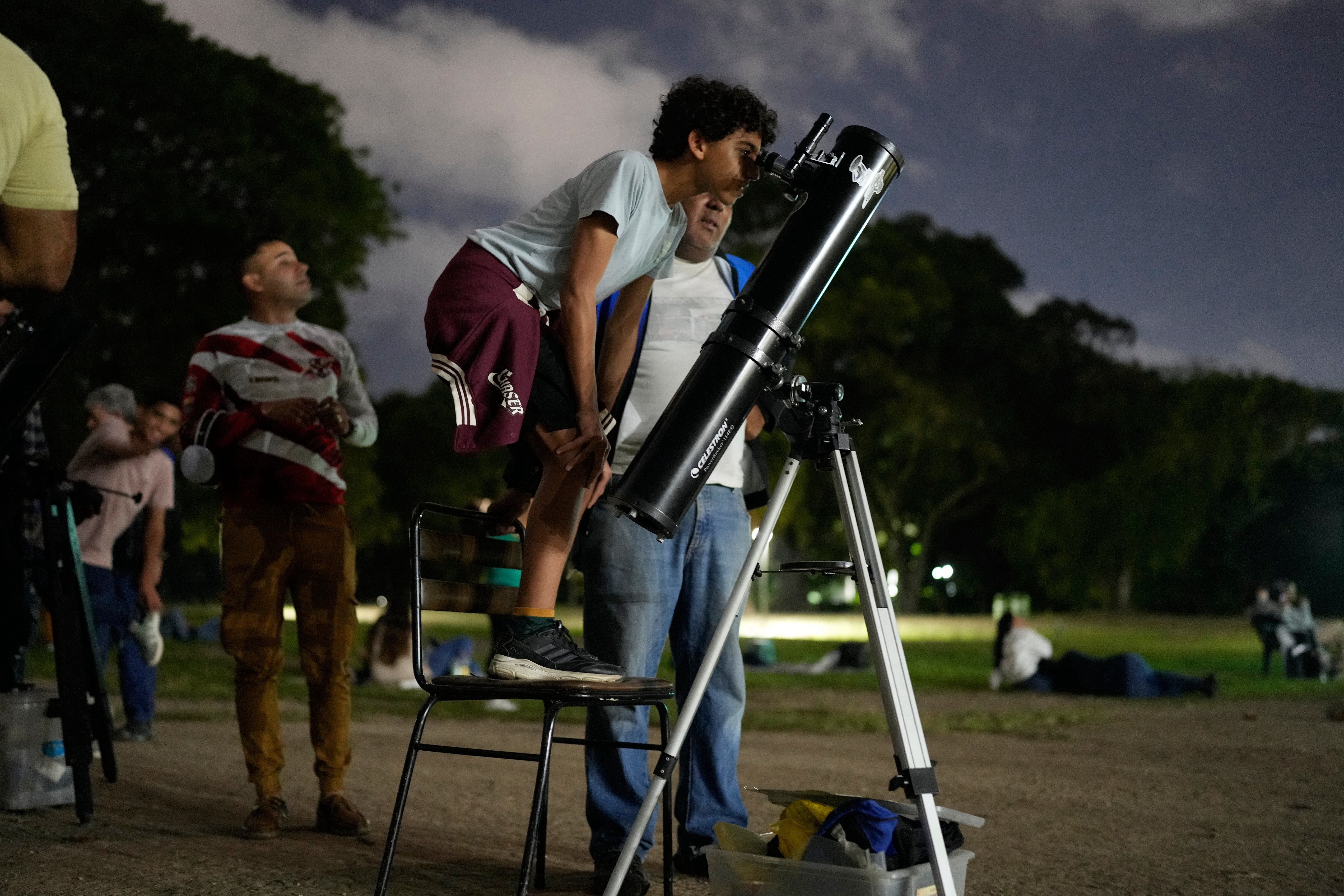 A boy looks at the moon through a telescope during a lunar eclipse in Caracas, Venezuela. (AP)