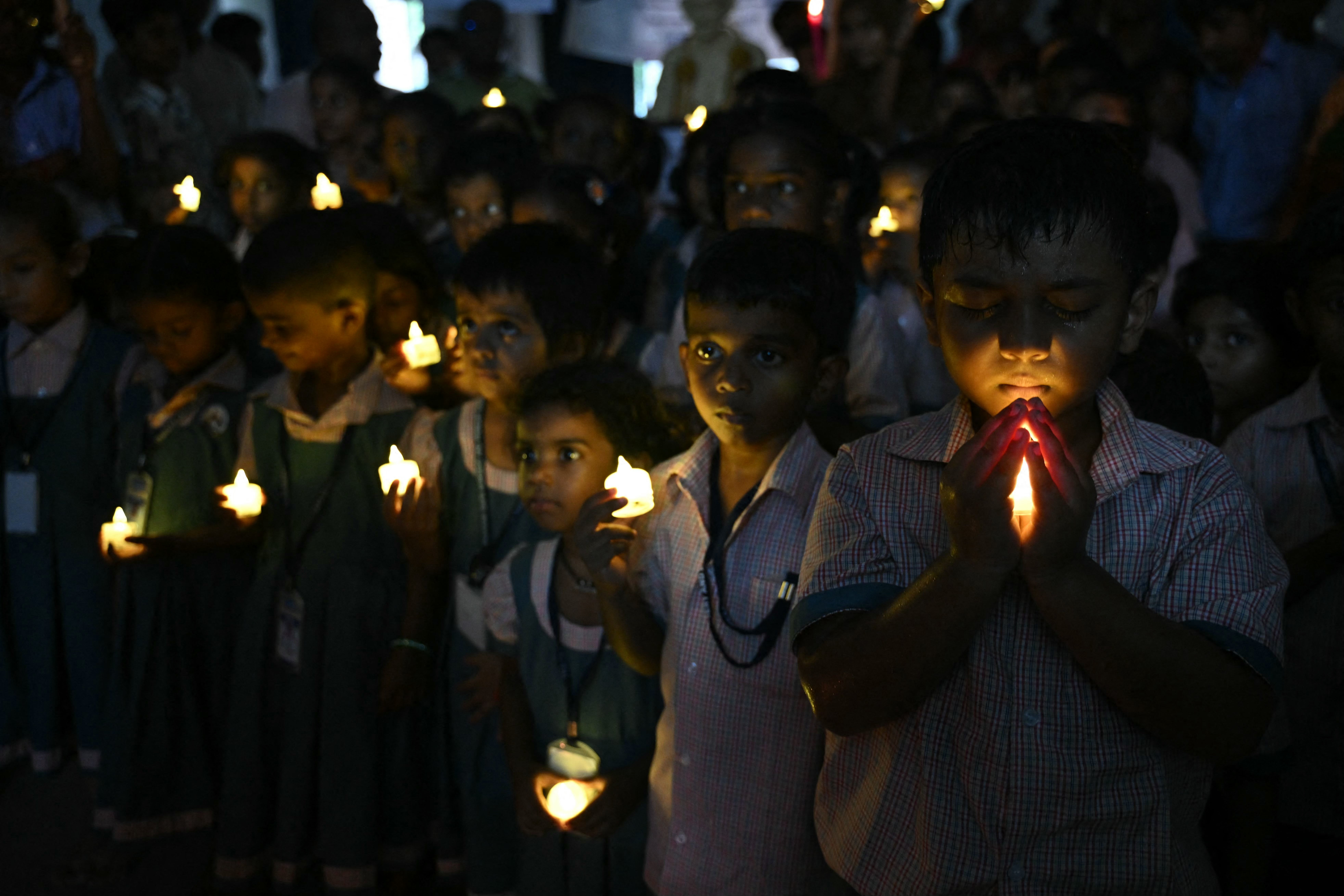 School students hold LED candles as they gather to pay their homage to people who died in Nepal's flash flood, in Chennai