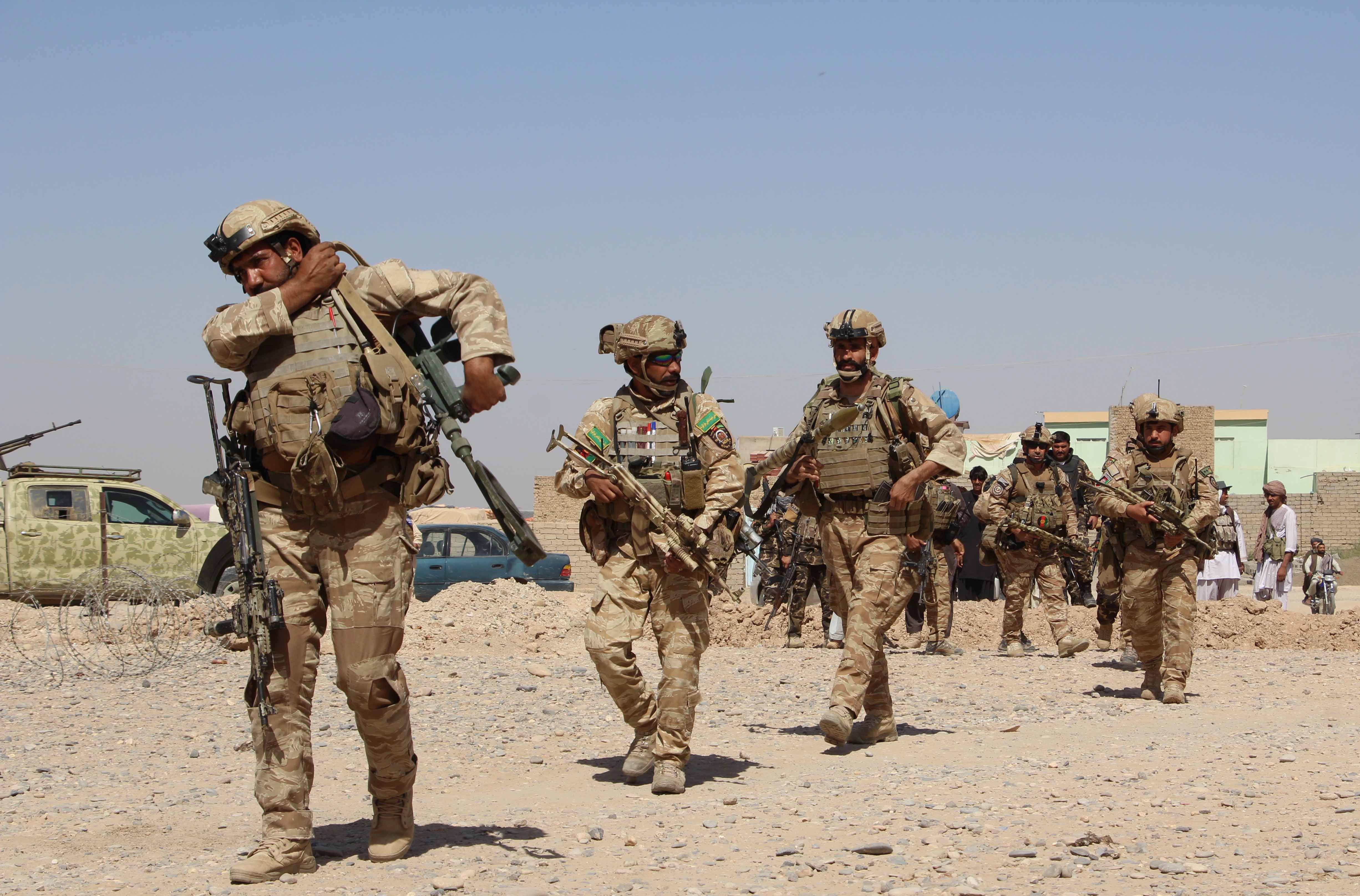 In this photograph taken on October 9, 2016, Afghan National Army commandos take position during a military operation in Helmand province.