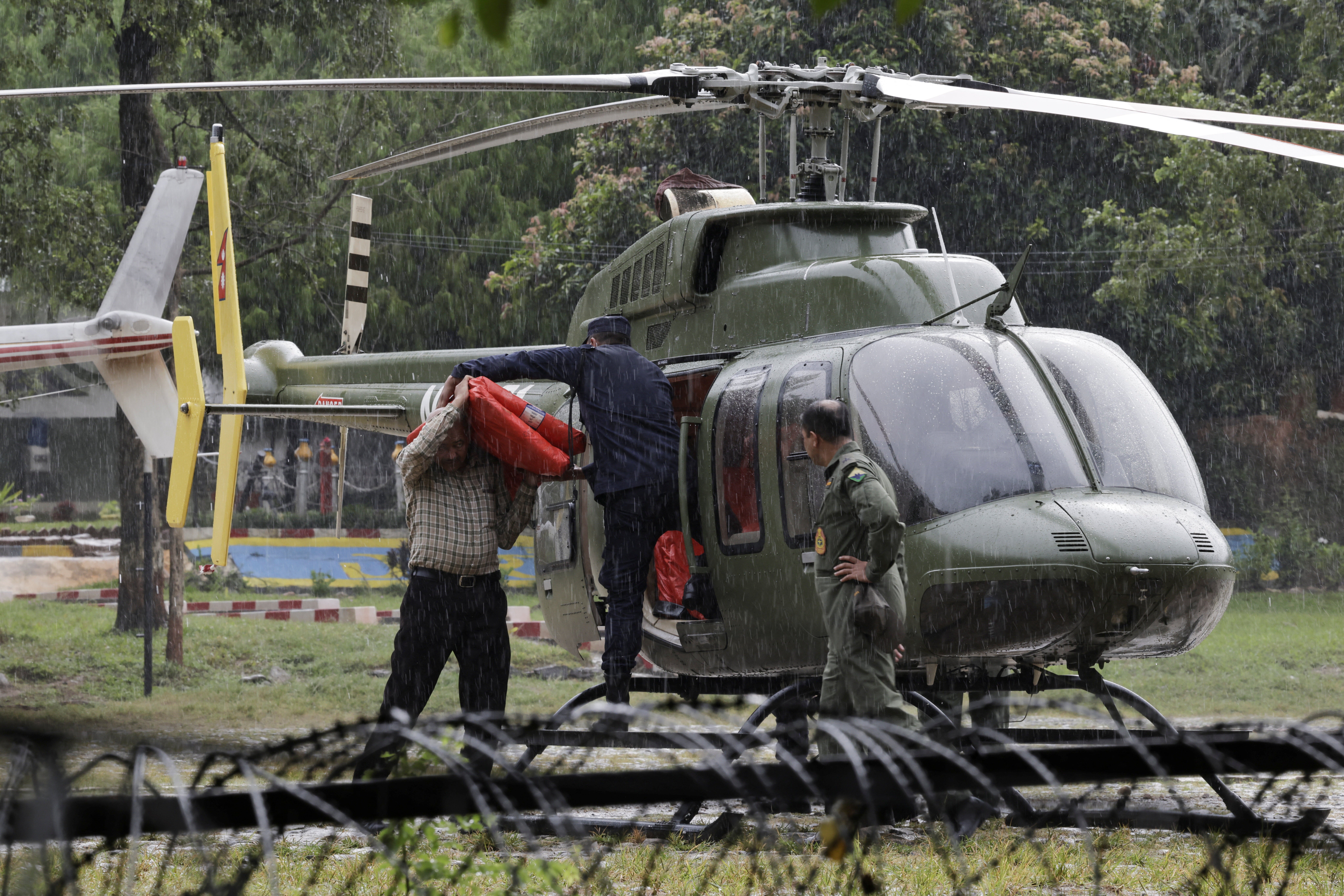 Rescuer load relief material in a helicopter to be transported to the areas affected by flash floods and a mudslide as it drizzles at the Maithali Barrack, an army training center, in Trishuli, Nuwakot district, Nepal